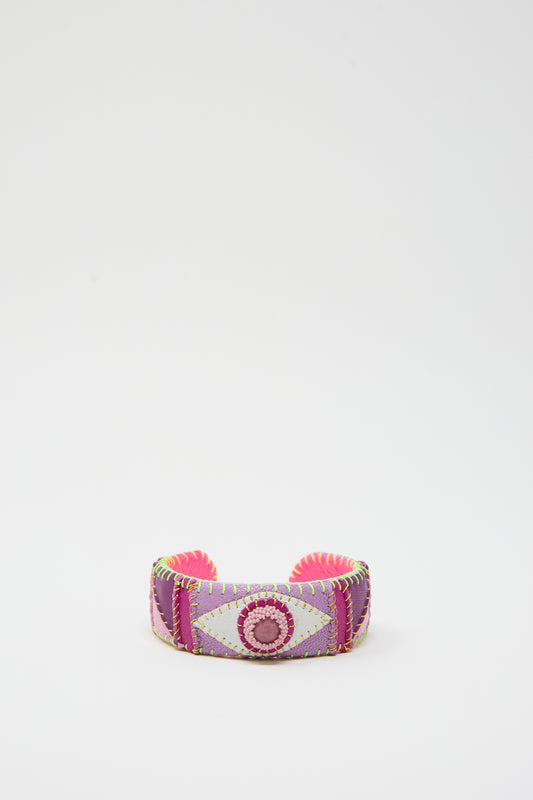 The Eye Cuff in Rhodonite by Robin Mollicone is a vibrant, hand-stitched leather accessory featuring a geometric design with pink, purple, and green stitching on a white background, crafted meticulously in New York.