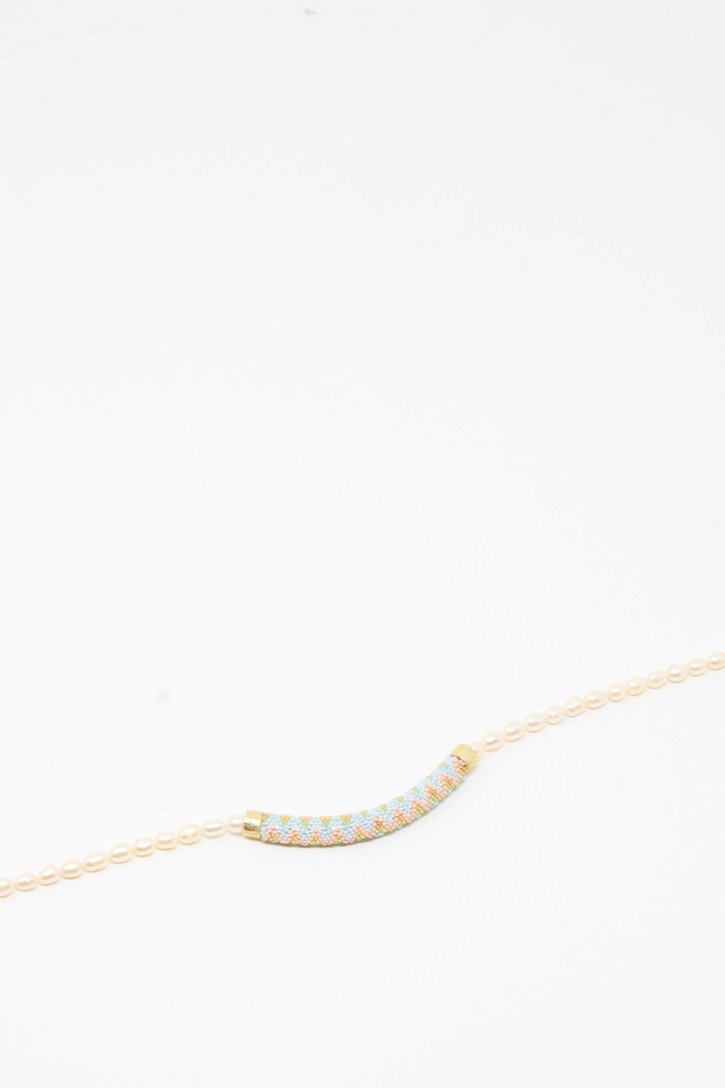 Fresh Water Pearl Beaded Bar Necklace by Robin Mollicone displayed on a plain white background—a striking handmade piece featuring a curved, multicolored beaded bar pendant that adds a vibrant touch to any collection.