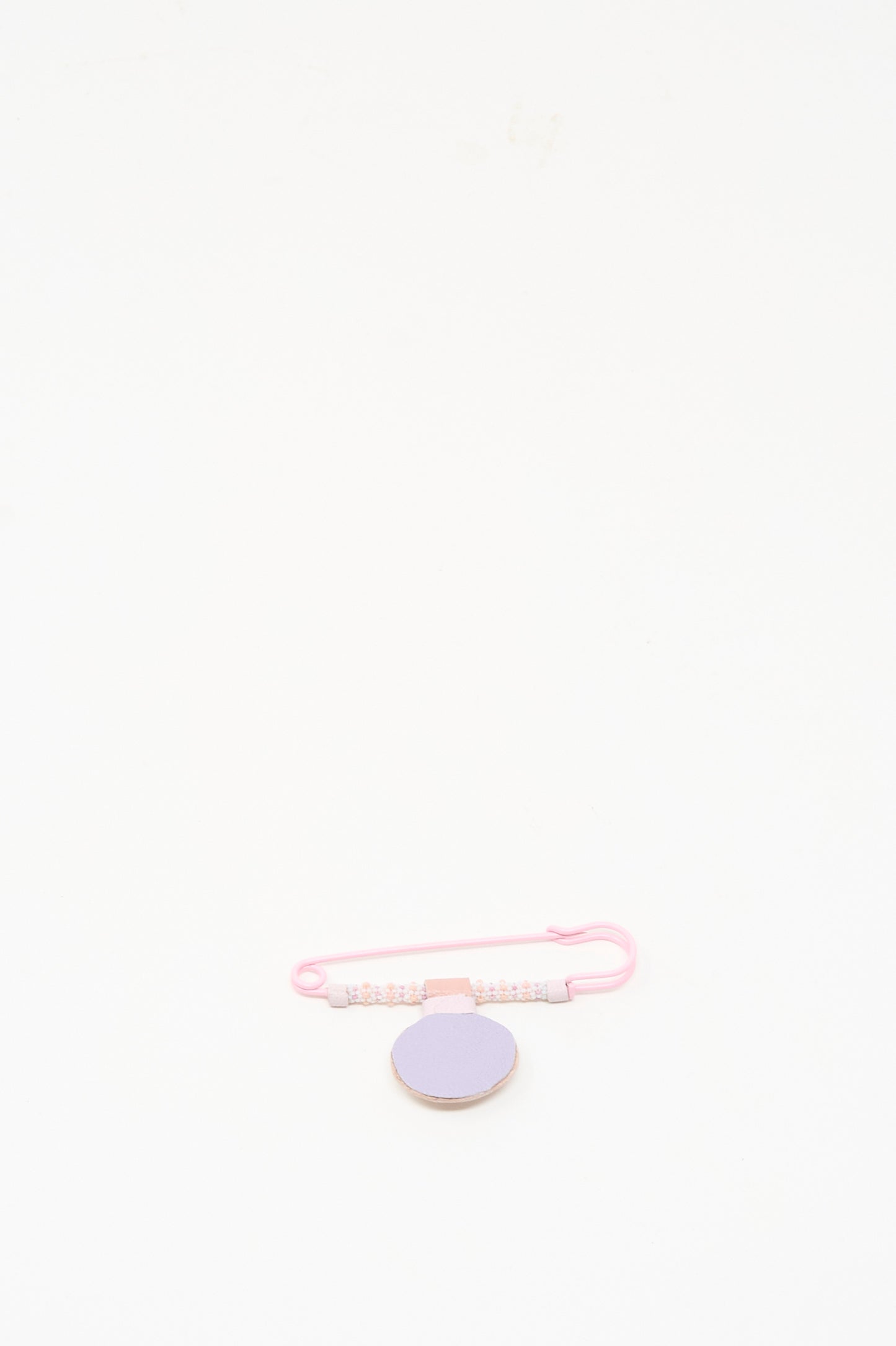 The Gem Drop Brooch in Pink Moonstone by Robin Mollicone, handmade in NYC, features pink beads and a lavender round accent, displayed on a plain white background.