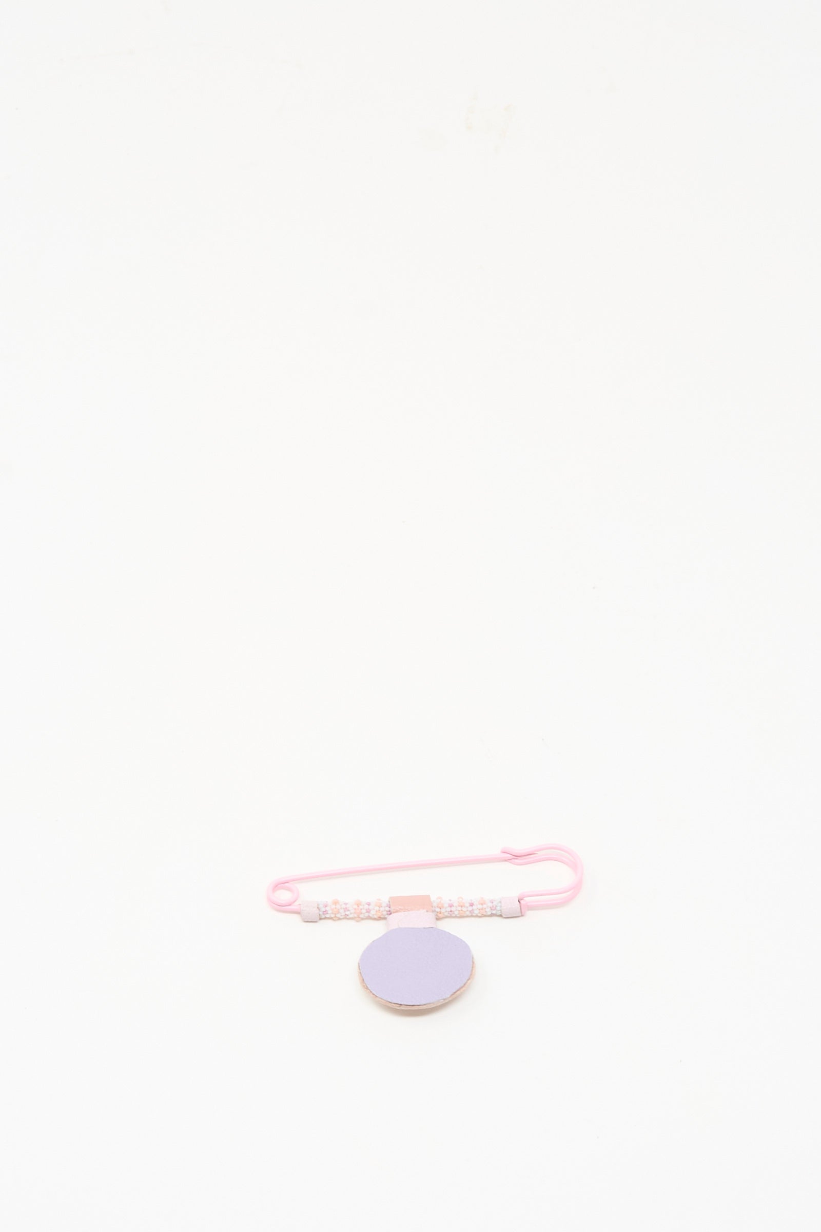 The Gem Drop Brooch in Pink Moonstone by Robin Mollicone, handmade in NYC, features pink beads and a lavender round accent, displayed on a plain white background.
