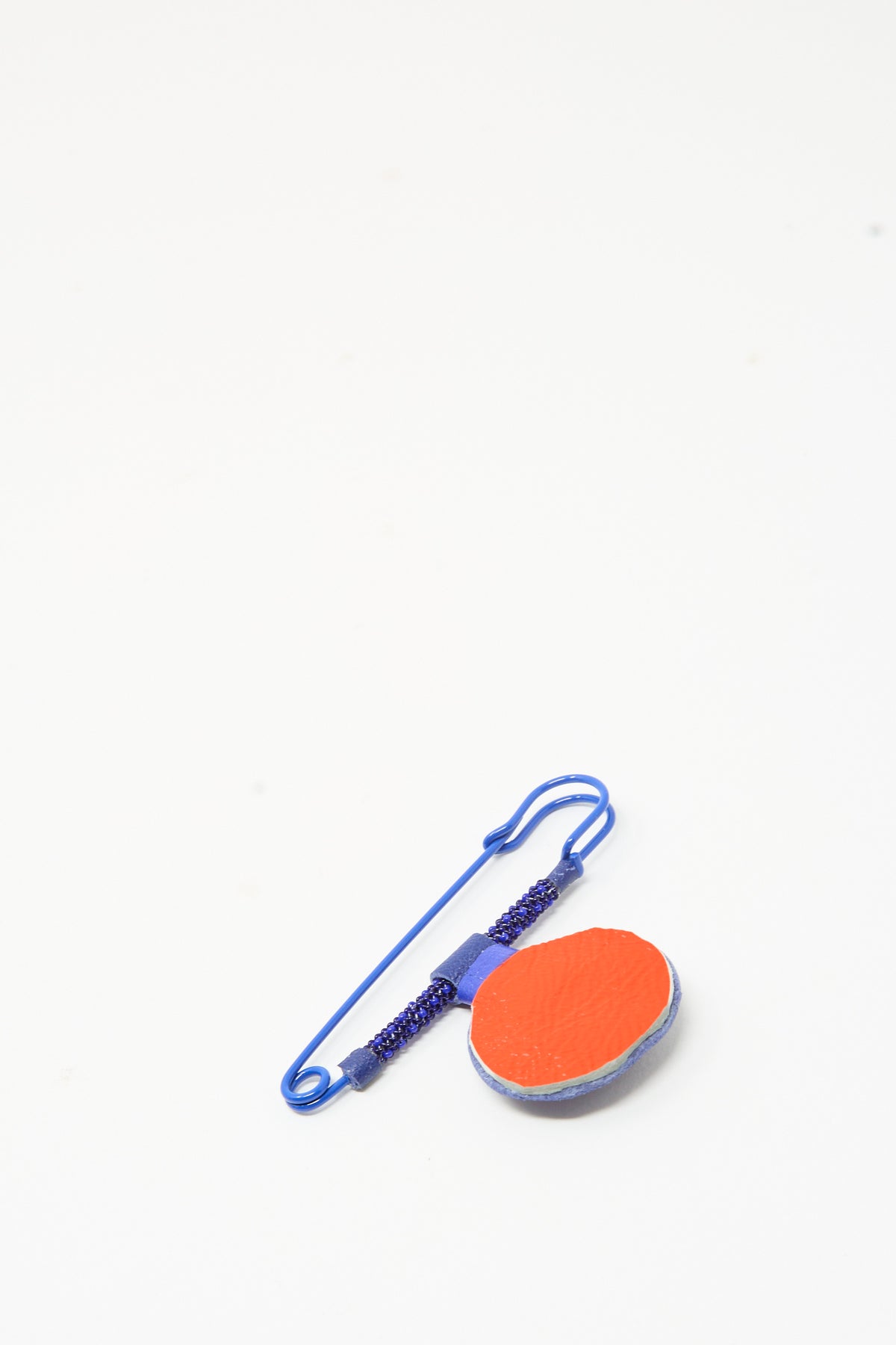 Robin Mollicone Gem Drop Safety Pin in Blue Sodalite featuring a beaded coil and a round, orange-faced pendant, handmade in New York.