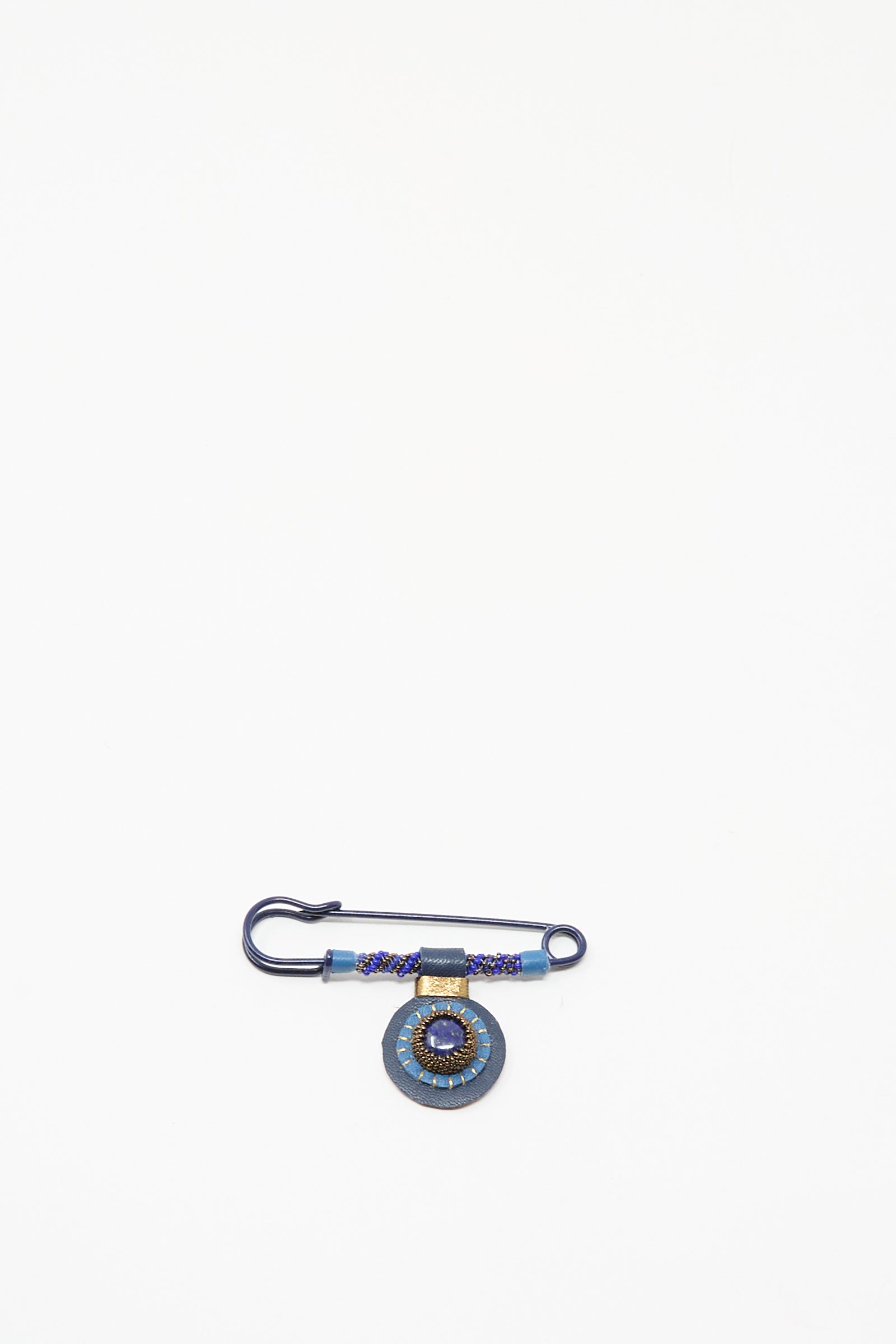 The Gem Drop Safety Pin in Lapis by Robin Mollicone is a handmade dark blue beaded pin from NYC, featuring a round lapis-detailed pendant, shown on a plain white background.