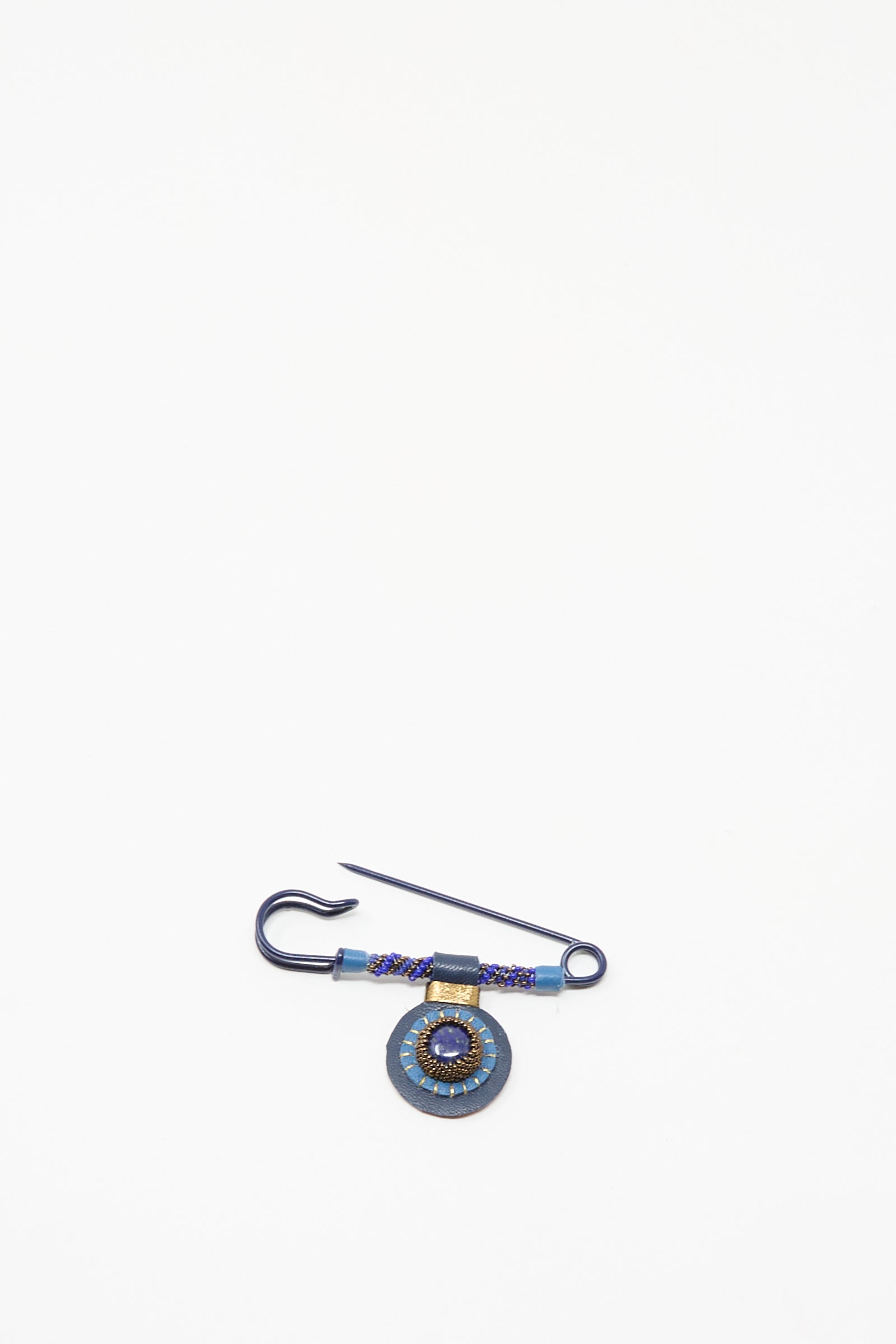 The Gem Drop Safety Pin in Lapis by Robin Mollicone features intricate beadwork and a lapis pendant, handmade in NYC and displayed on a plain white background.