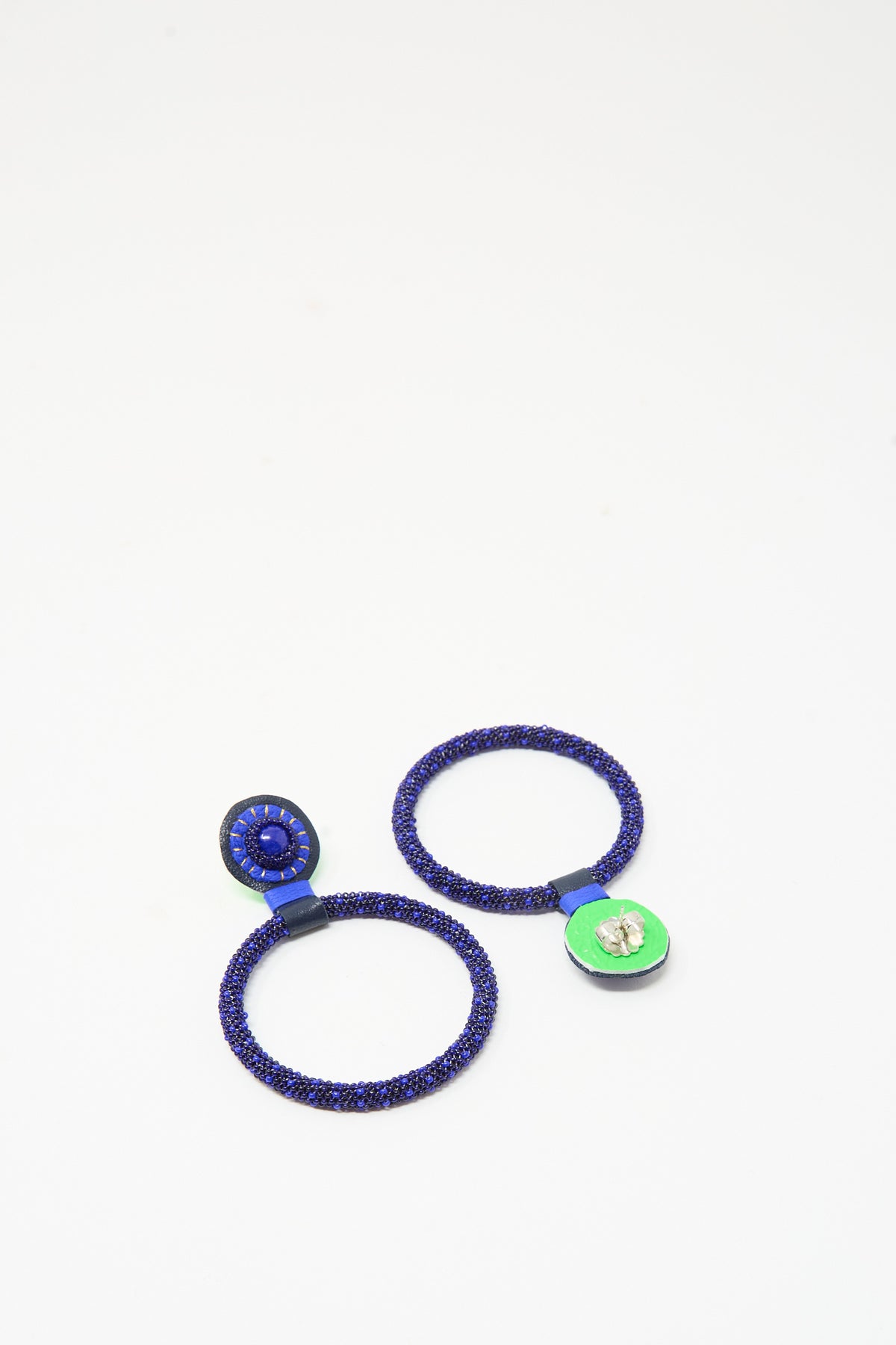 Robin Mollicone Large Beaded Hoops in Blue Lapis: two beaded hoop earrings covered in small blue beads, featuring a blue stone post on one side and a green backing on the other.
