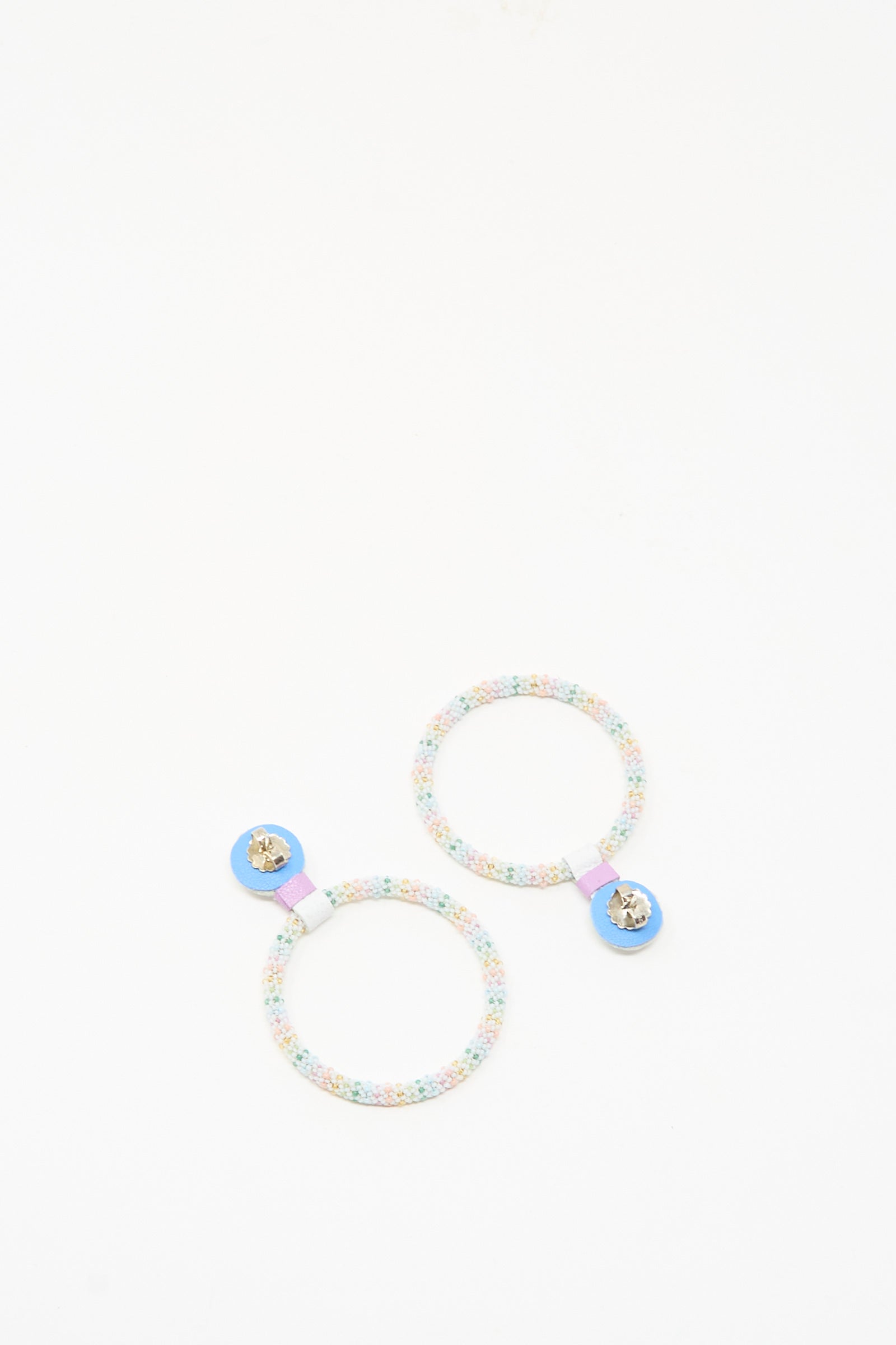 The Large Beaded Hoops in Rainbow Moonstone by Robin Mollicone feature colorful beads and blue accents, reminiscent of bejeweled hair accessories, and are showcased against a plain white background.