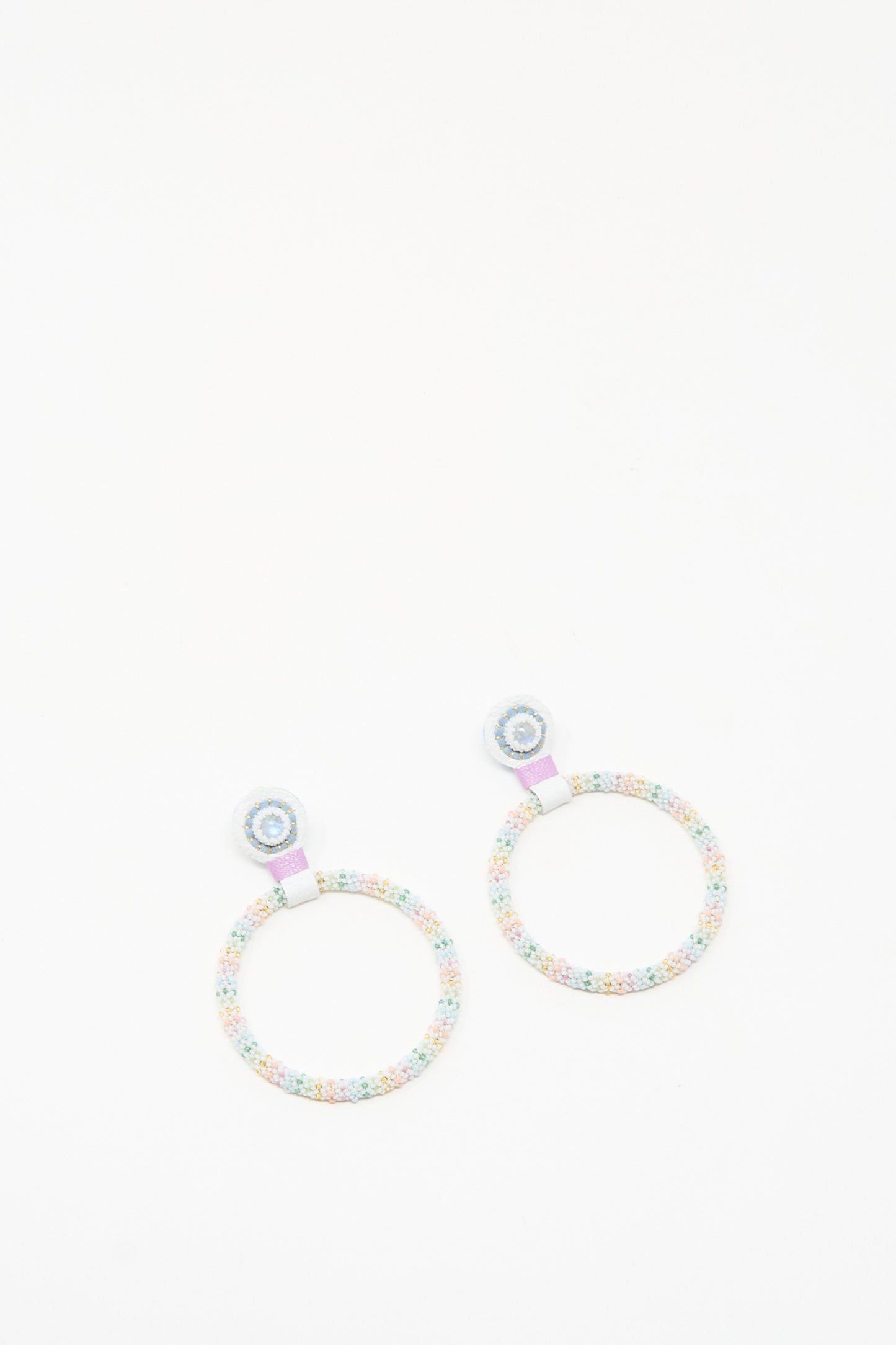 The Large Beaded Hoops in Rainbow Moonstone by Robin Mollicone are handmade earrings with pastel beads and a circular design, featuring a small stud and larger loop—ideal for adding subtle charm to any outfit.