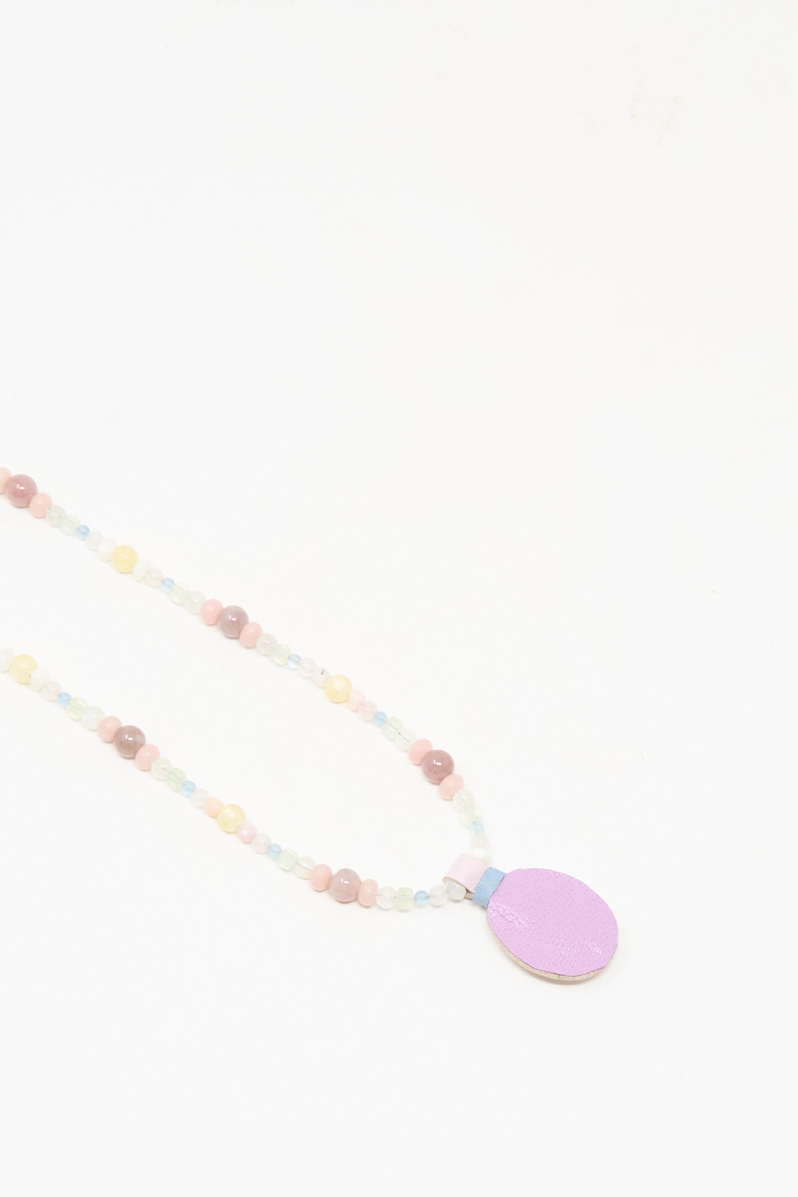 The Robin Mollicone Love Bead Charm Necklace in Pink Moonstone showcases pastel vintage glass beads and a flat, oval lavender pendant, displayed against a white background.