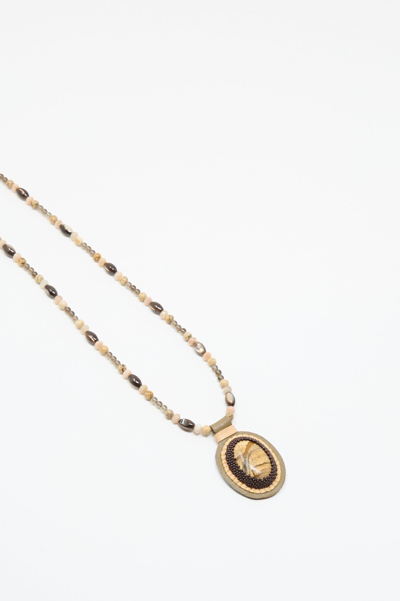 The Love Bead Necklace in Brown by Robin Mollicone features tan, brown, and black beads with an oval picture jasper charm and woven border, shown on a white background.