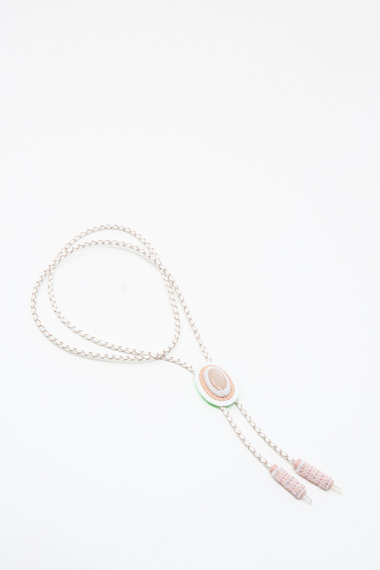 The Robin Mollicone Moonstone, Quartz Bolo Necklace in Pink and White features a handmade braided design with an oval pink moonstone centerpiece and two pink cylindrical tips, displayed on a white background.