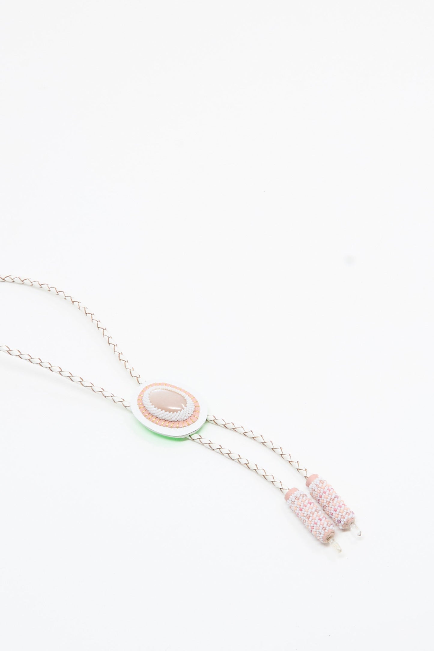 A delicate Moonstone and Quartz bolo necklace in pink and white by Robin Mollicone, featuring a pink moonstone oval centerpiece and two pastel beaded tassels, displayed on a white background.