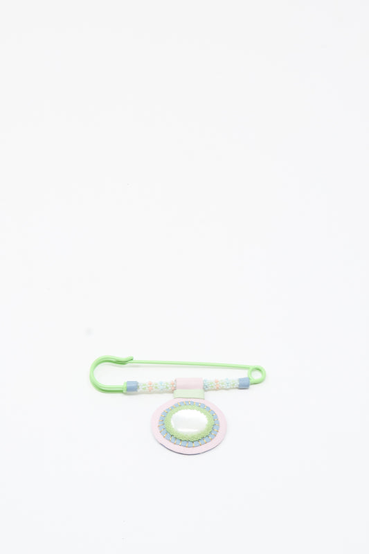 The Mother of Pearl Gem Drop Brooch in Pink, Blue, and Green by Robin Mollicone features pastel beads and a round Mother of Pearl ornament on a safety pin, beautifully handmade in NYC and displayed on a white background.