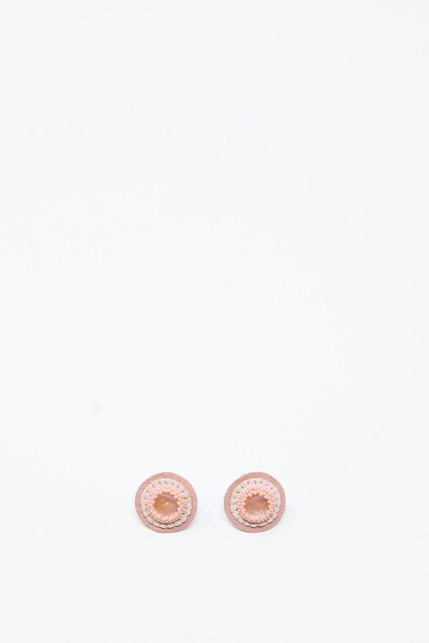 Two Mother of Pearl Stud Earrings in Pink by Robin Mollicone are placed side by side on a plain white background.