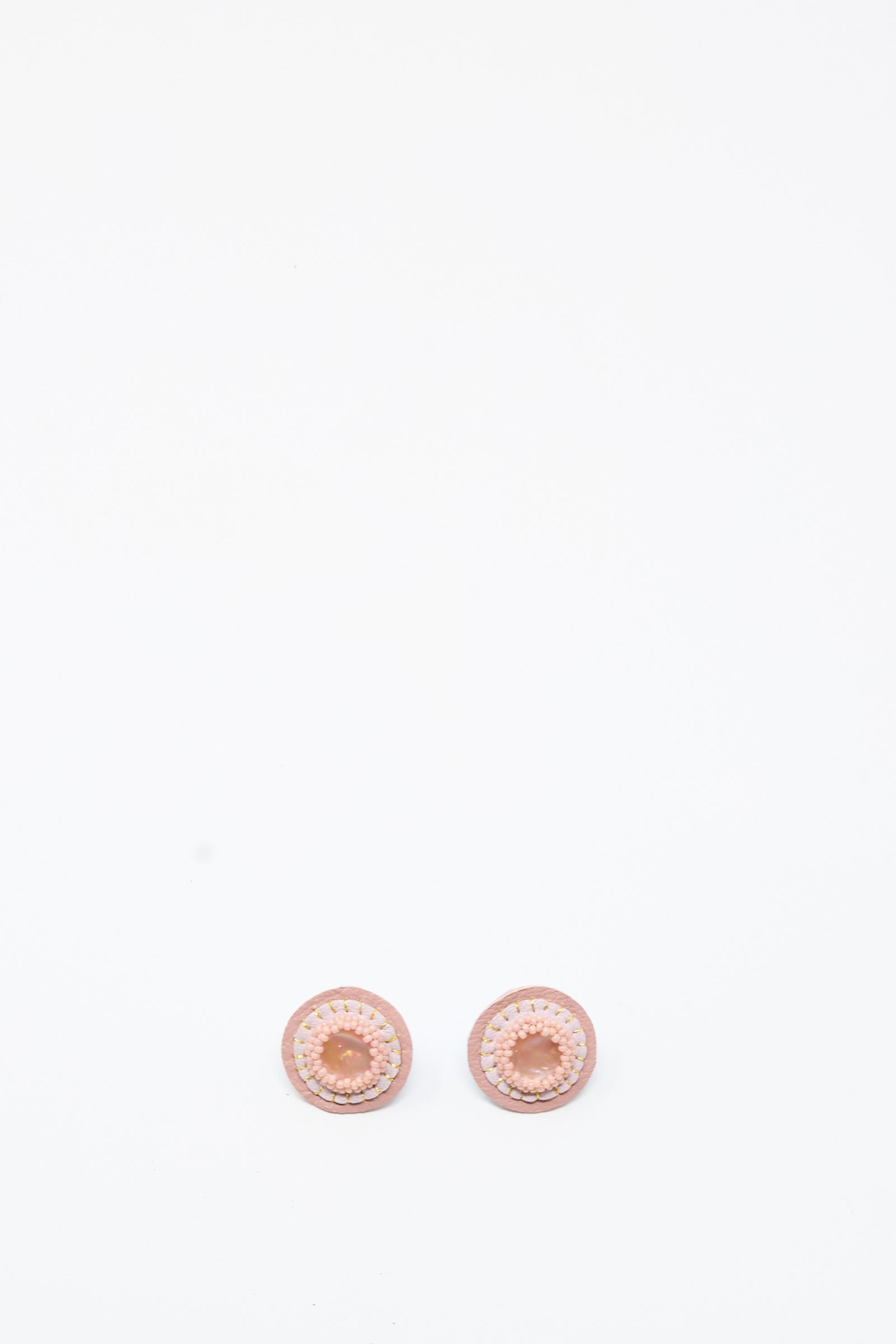 Two Mother of Pearl Stud Earrings in Pink by Robin Mollicone are placed side by side on a plain white background.
