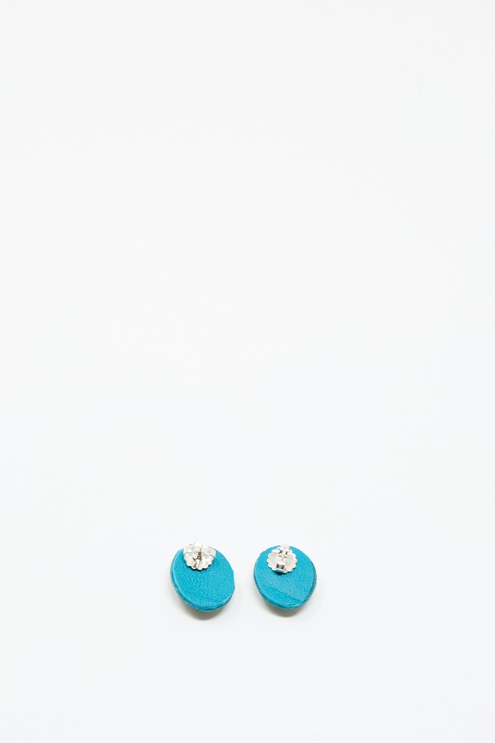 The Oval Earrings in Apatite by Robin Mollicone feature turquoise hues with small silver or clear gemstone accents, shown against a plain white background.