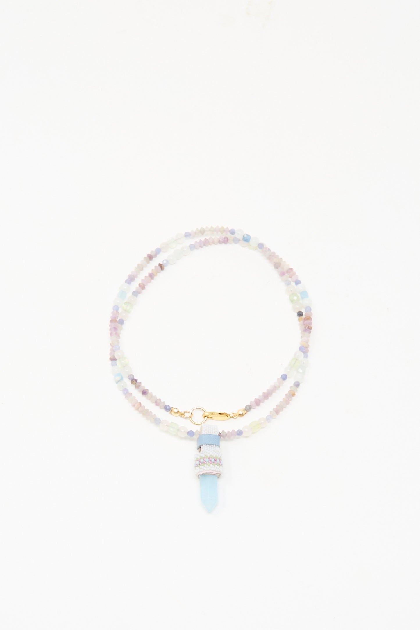 The Peace of Mind Necklace in Aquamarine by Robin Mollicone features pastel beads, a gold clasp, and an aquamarine pendant, presented against a white background.
