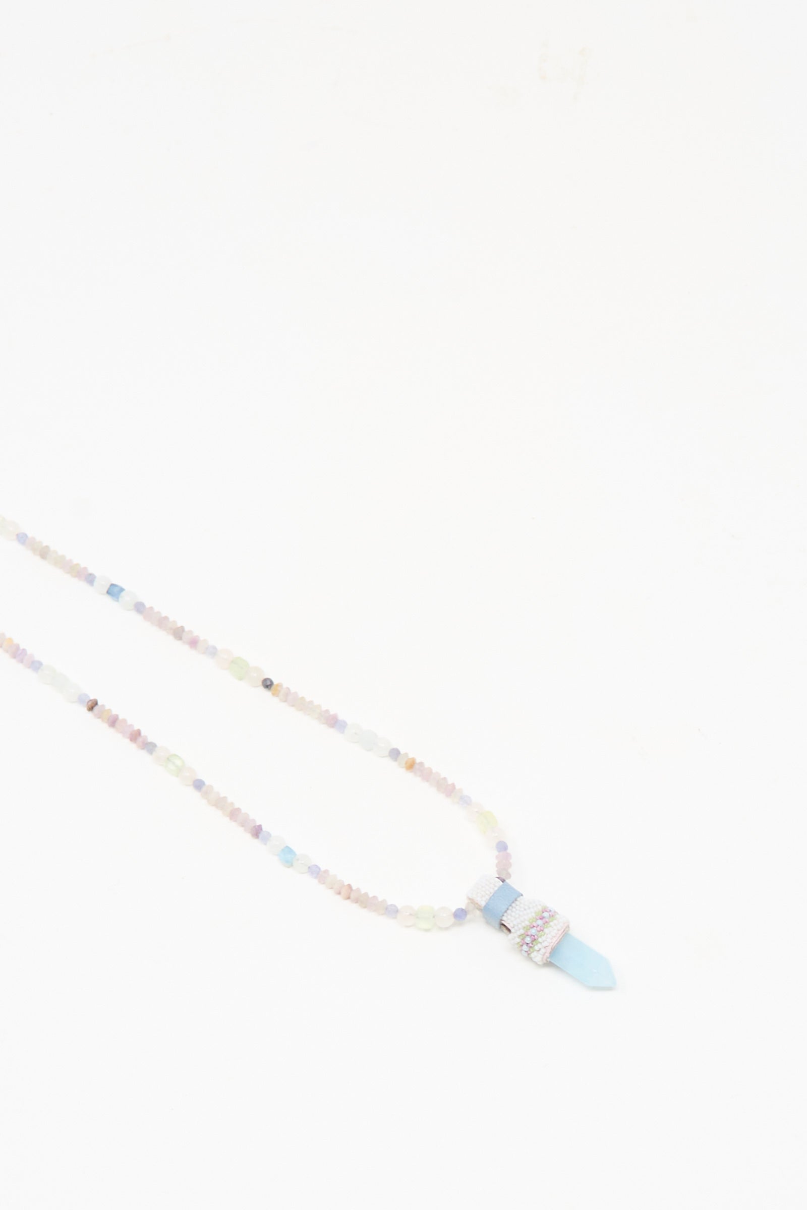 The Peace of Mind Necklace in Aquamarine by Robin Mollicone features pastel beads and a blue quartz crystal pendant, shown against a plain white background.