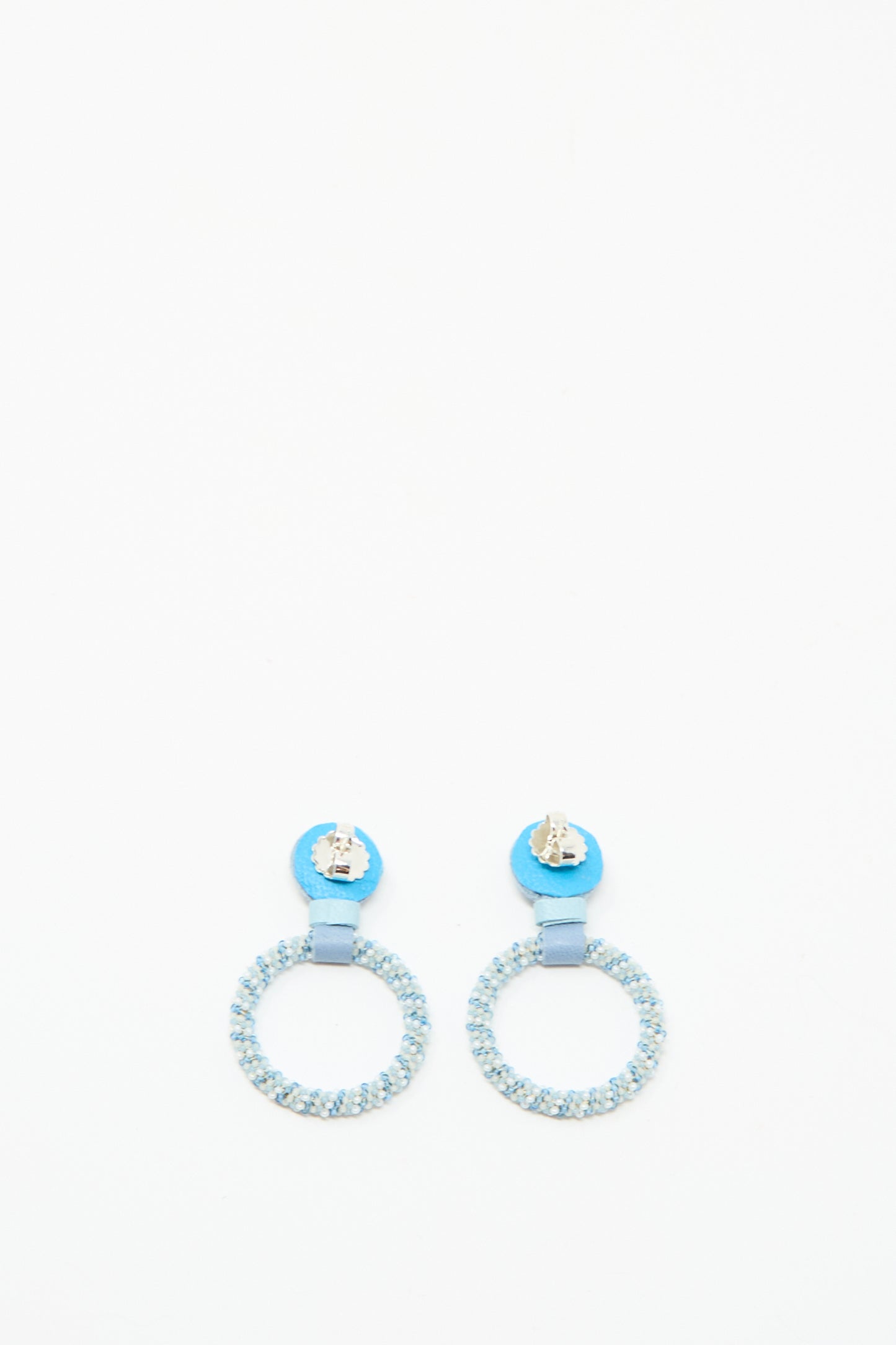 Small Beaded Hoop Earrings in Mother of Pearl by Robin Mollicone, featuring round light blue beads and metallic blue circular studs, handmade in NYC and shown on a plain white background.