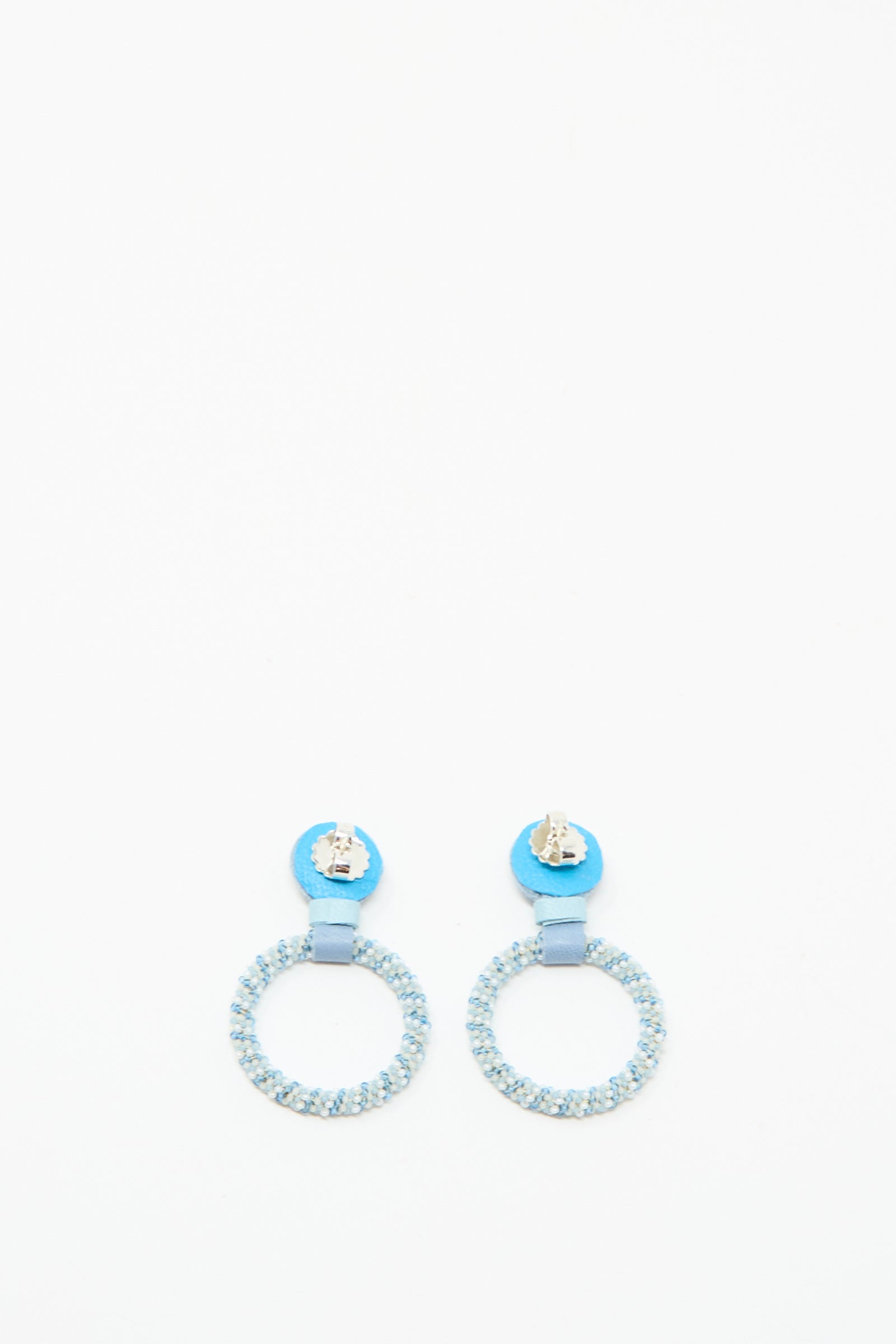 Small Beaded Hoop Earrings in Mother of Pearl by Robin Mollicone, featuring round light blue beads and metallic blue circular studs, handmade in NYC and shown on a plain white background.