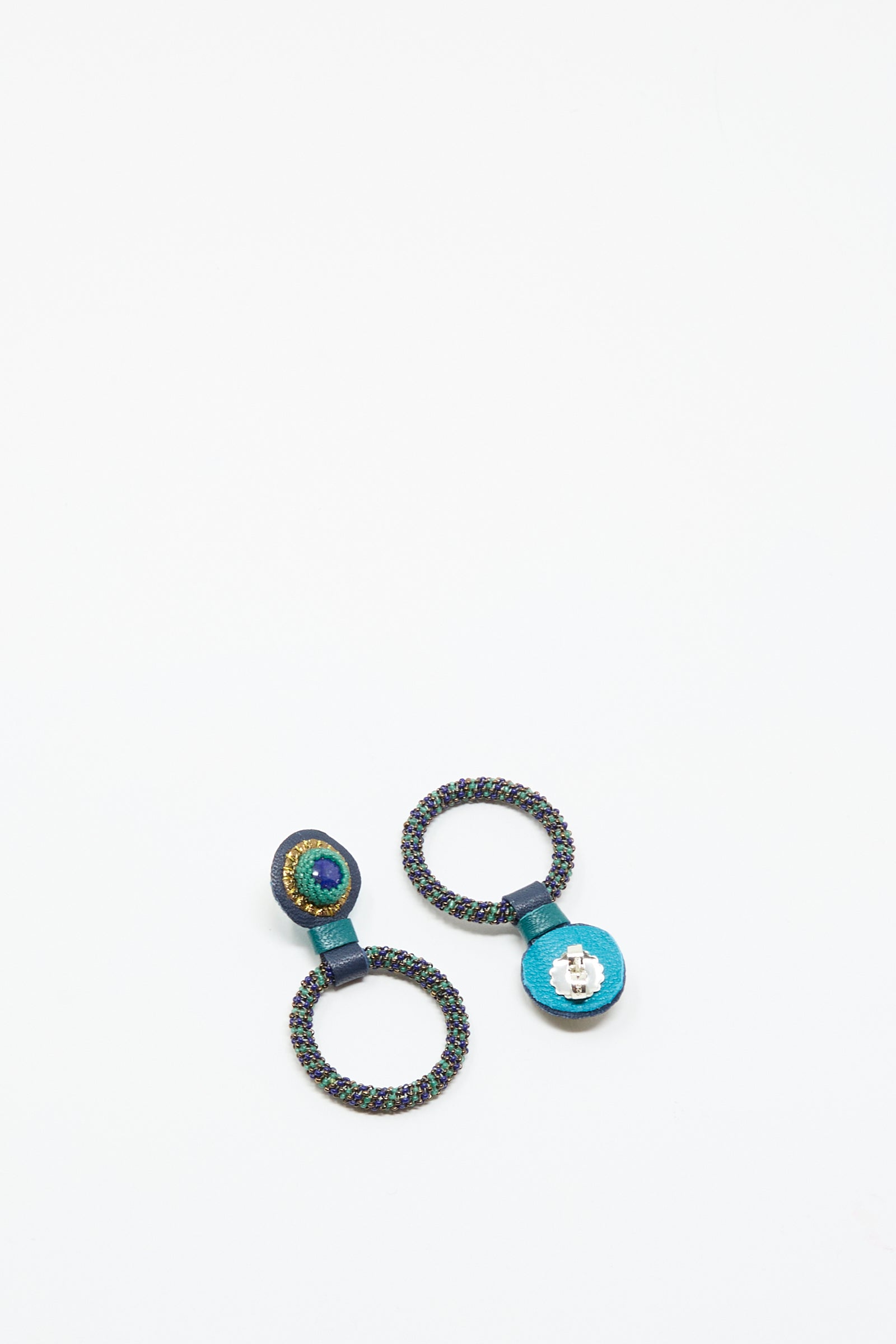 The Robin Mollicone Small Beaded Hoops in Blue with Lapis are handmade circular earrings, featuring beaded hoops with blue accents, shown on a white background.