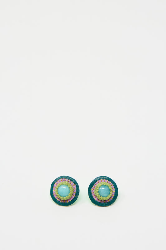 Introducing the Robin Mollicone Stud Earrings in Amazonite: a pair of round, handmade earrings featuring a central amazonite blue bead, an outer border of green beads, and multiple colorful rings in between, all set against a plain white background.