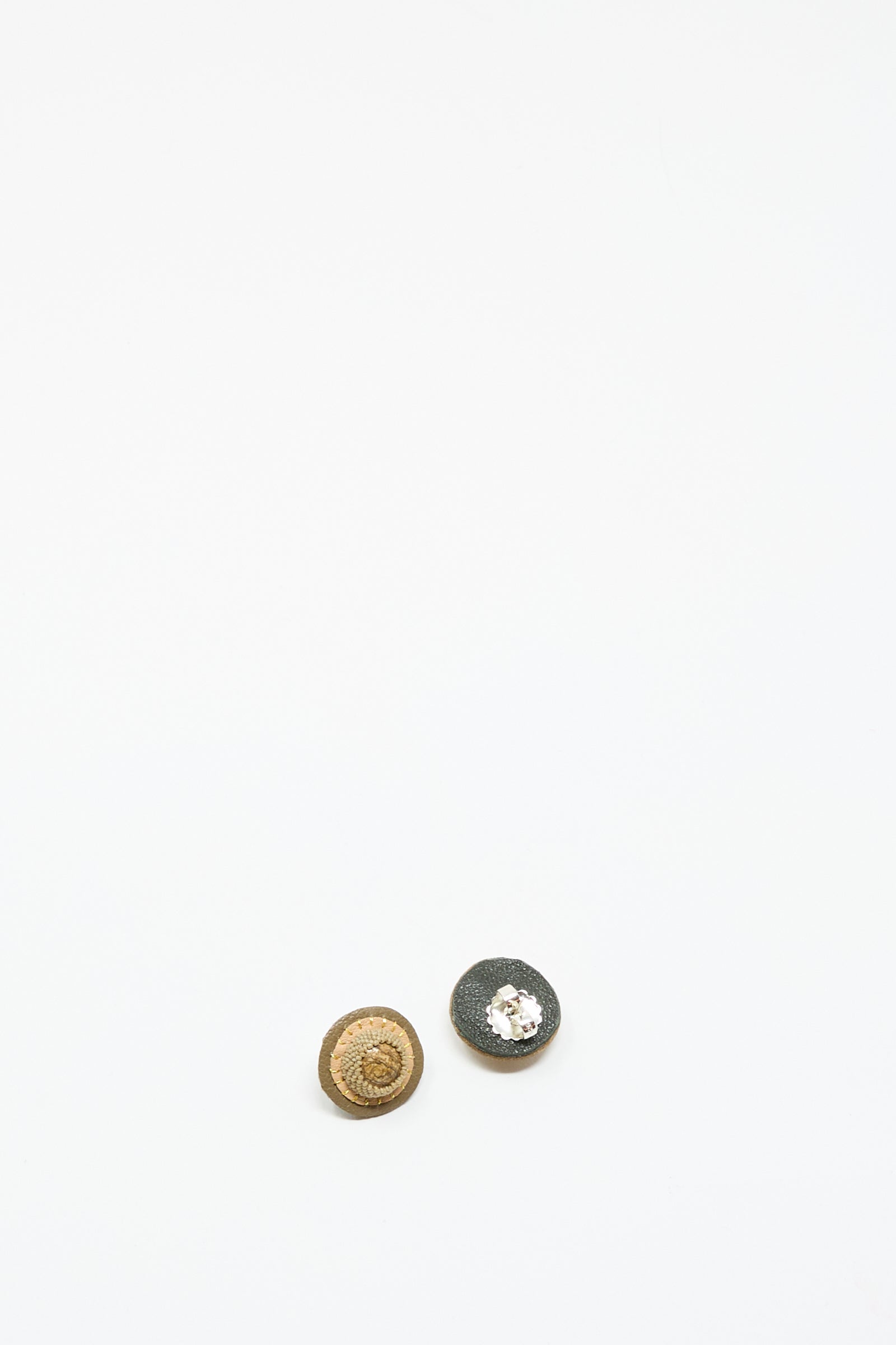 Two small, round Robin Mollicone Stud Earrings in Brown with Picture Jasper are displayed on a plain white surface near the bottom of the image.