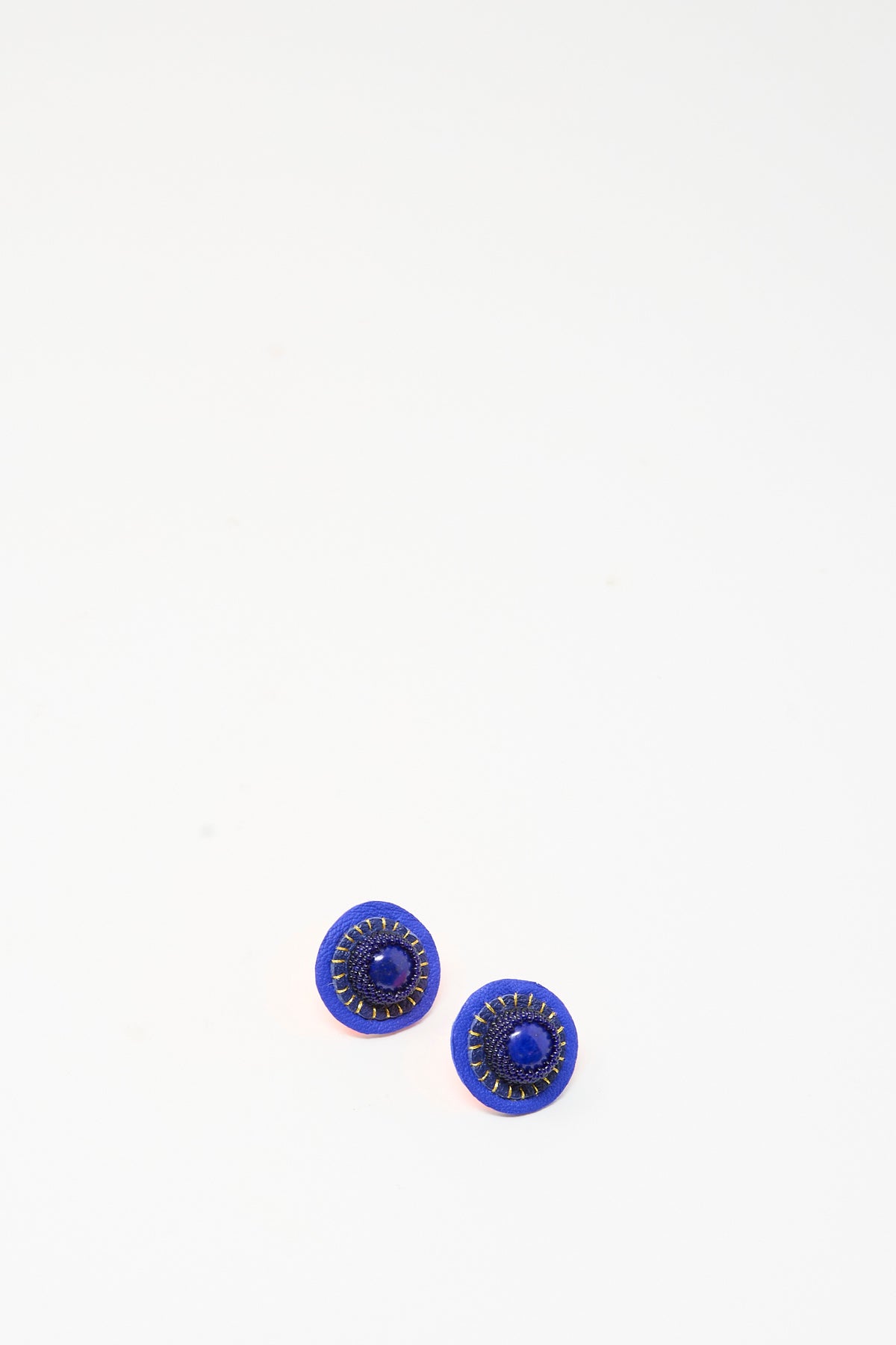 Robin Mollicone Stud Earrings in Lapis, featuring circular blue leather with central dark stones and stitched detailing.