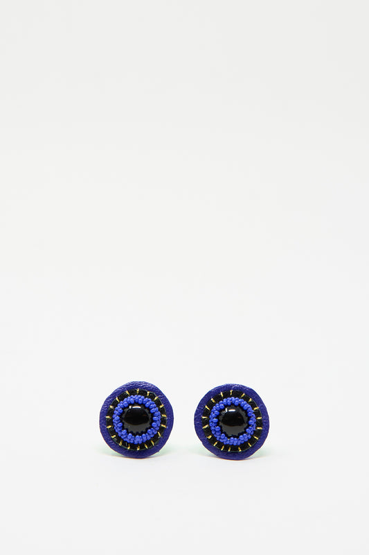 Introducing the Stud Earrings in Onyx by Robin Mollicone: these handcrafted, circular earrings feature a onyx center embellished with blue beads against a simple white backdrop. 