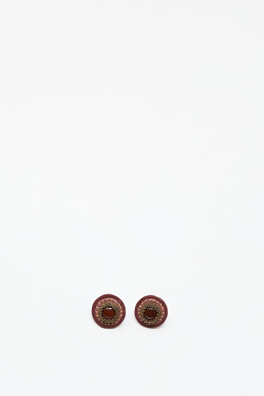 Two round, pink handmade stud earrings with carnelian by Robin Mollicone are placed side by side on a plain white background.