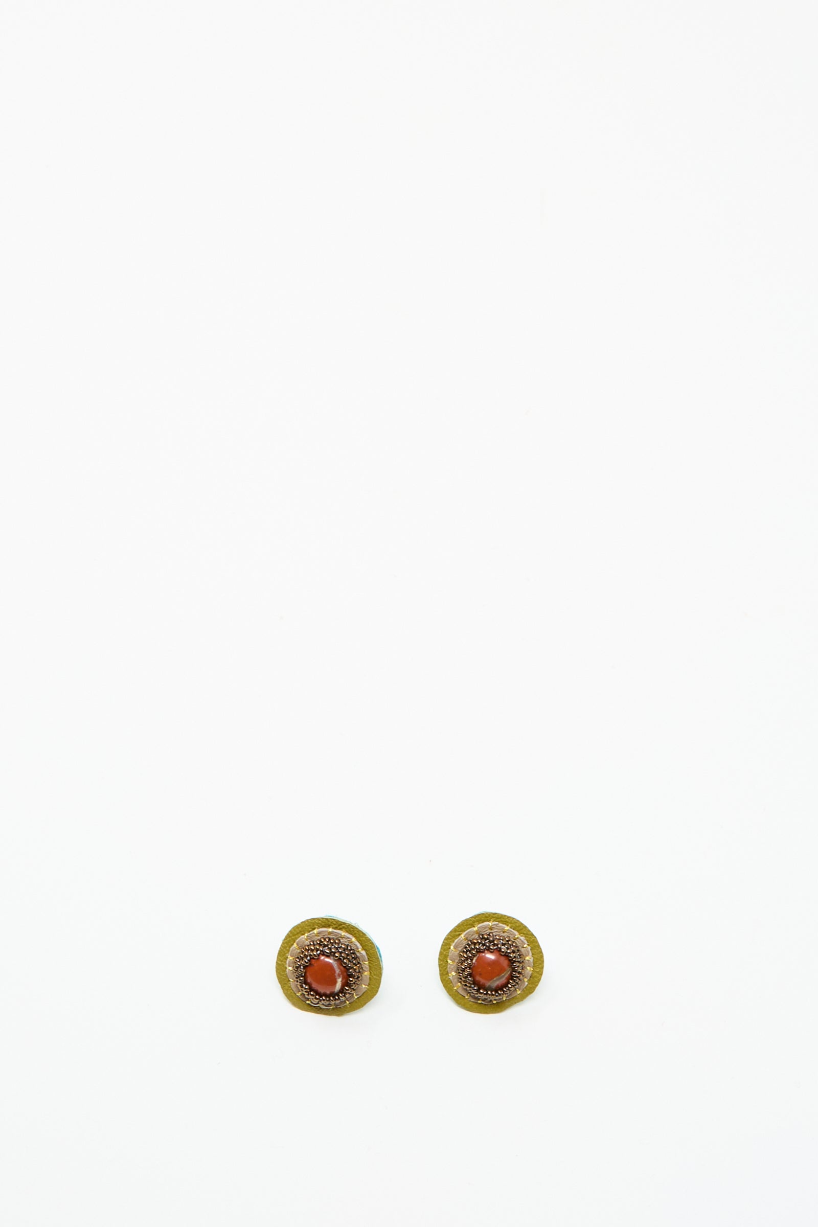 The Stud Earrings in Red Jasper by Robin Mollicone are round, handmade earrings with a gold outer ring and Red Jasper center, shown on a plain white background.