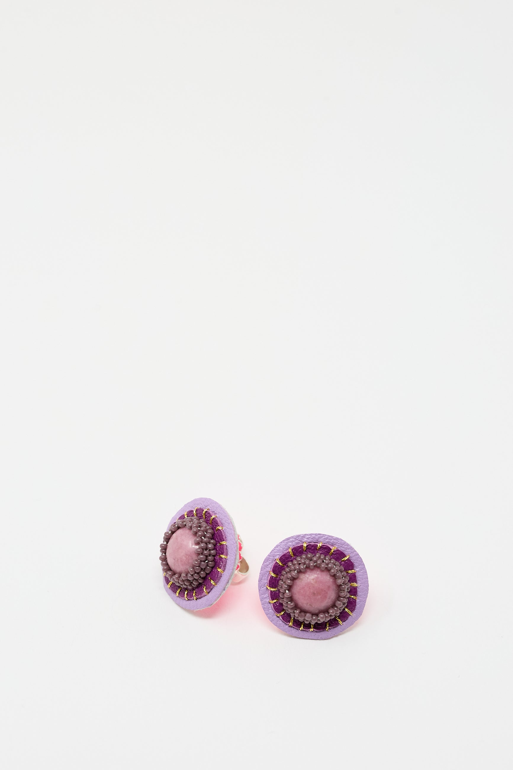 Pair of round, purple Stud Earrings in Rhodonite with pink and dark brown accents on a white background, meticulously handmade by Robin Mollicone.