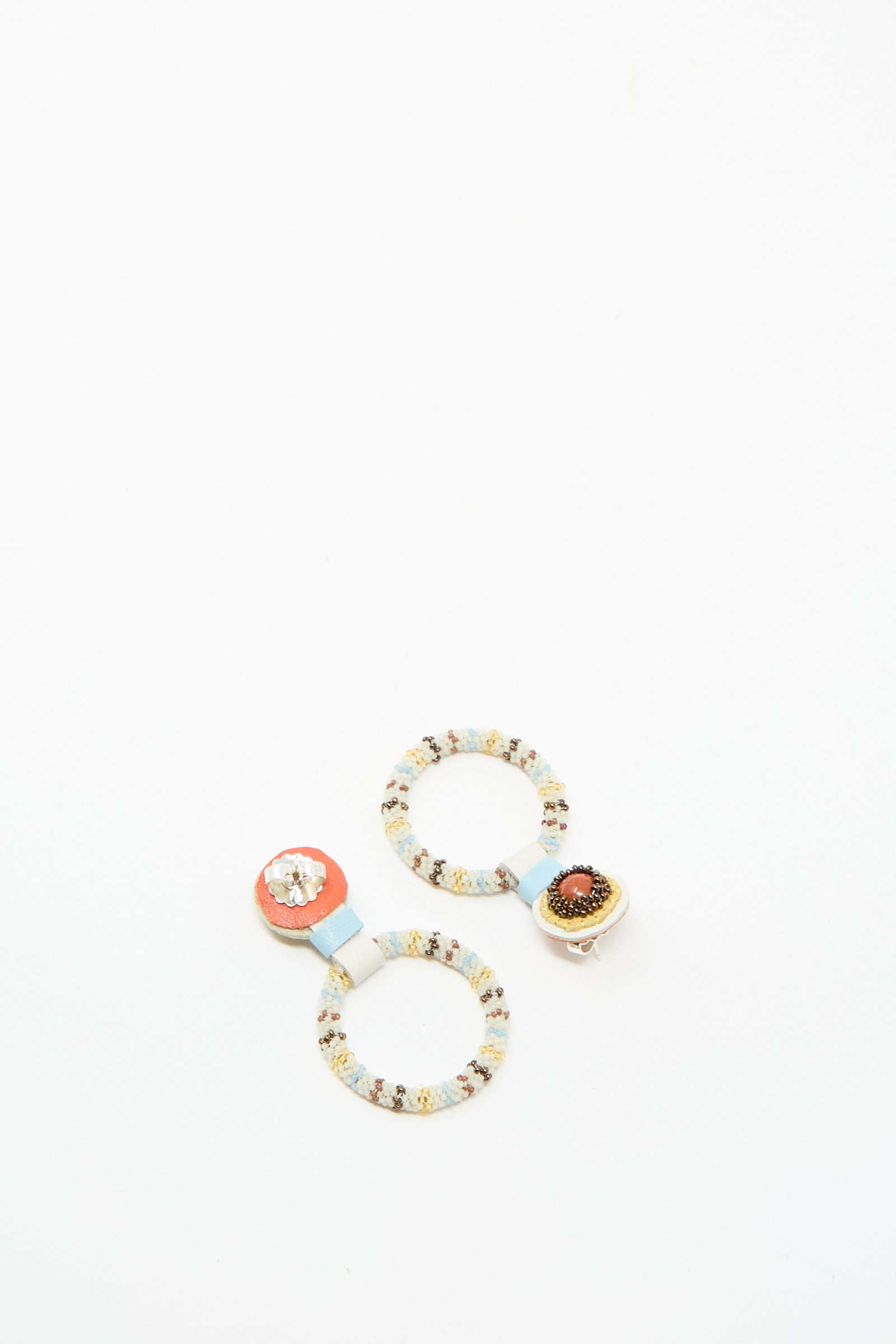Handcrafted in NYC by Robin Mollicone, these Small Beaded Hoop Earrings in Red Jasper feature two hoops joined by blue bands, each with a unique beaded center.