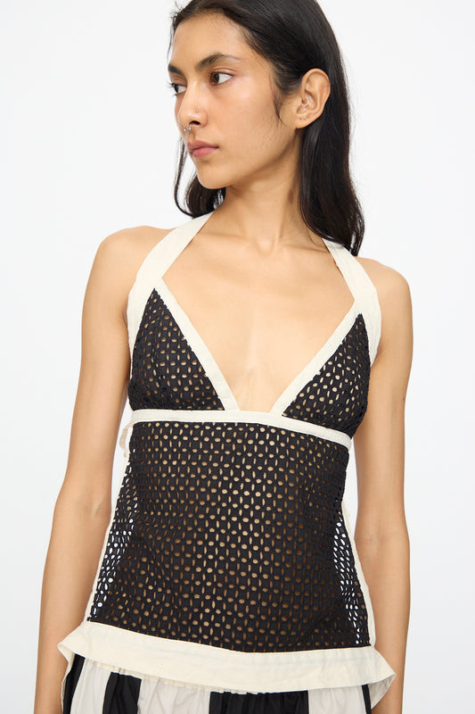 Person wearing the SC103 Cotton Eyelet Gaze Tank in Eclipse, a sleeveless top featuring white trim, made in NYC, looking to the side against a plain background.