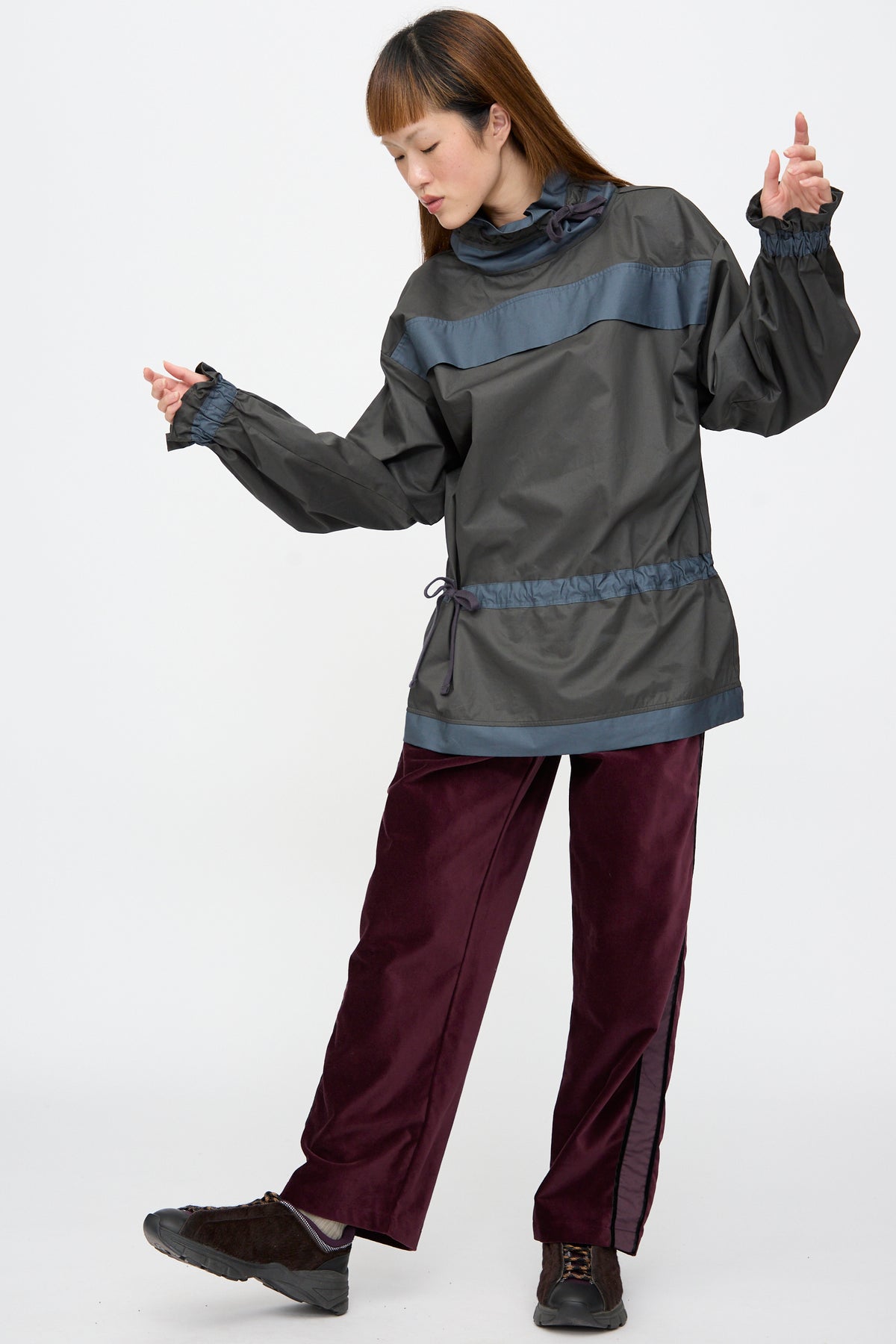 A person wearing a grey and blue cinched top with Cotton Velvet Chord Pants in Noble, a straight leg pant with a stripe down the leg.