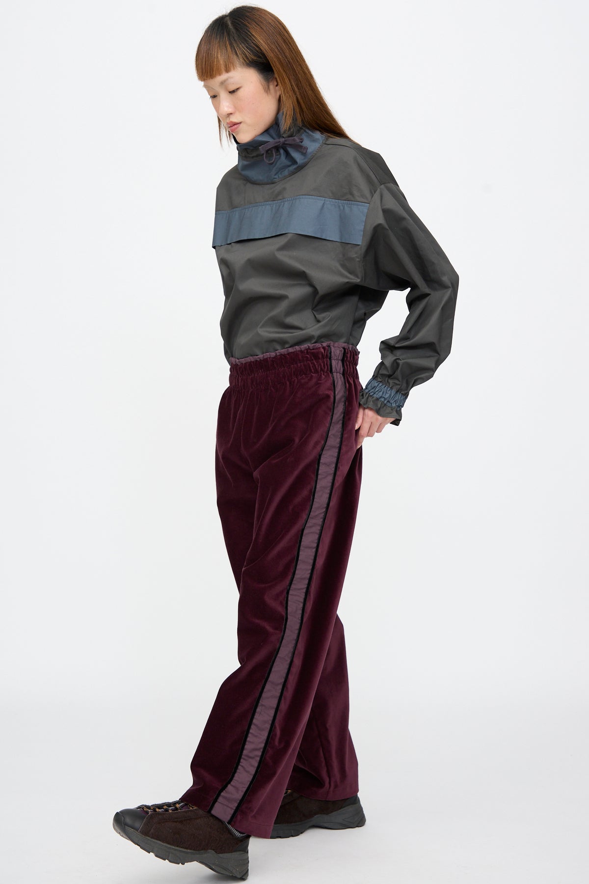 A person wearing a dark grey windbreaker and SC103 Cotton Velvet Chord Pants in Noble, featuring straight-leg and stripe down the leg.