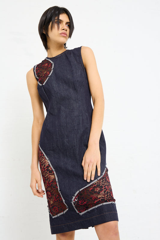 A woman modeling a sleeveless Denim Motto Dress in Weft with red floral embroidery and cutout lace detailing by SC103.