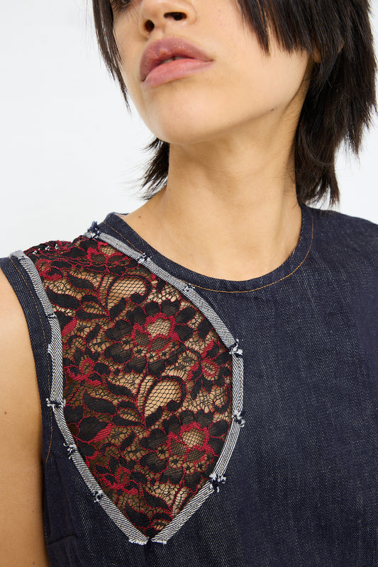 Close-up of a woman with a bob haircut wearing a sleeveless SC103 Denim Motto Dress in Weft with cutout lace detailing.