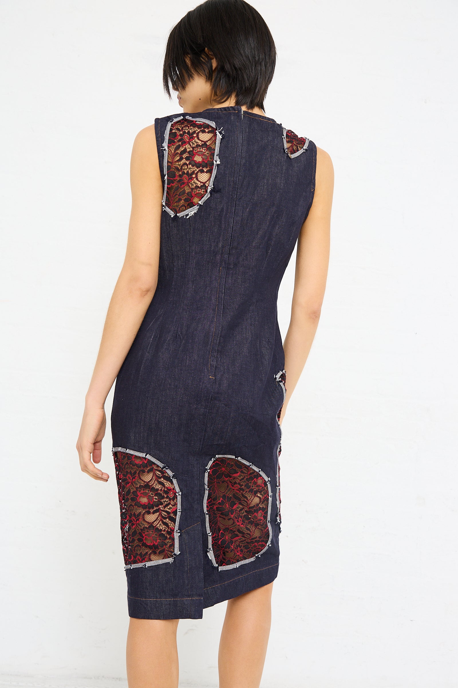 A woman from behind wearing a sleeveless Denim Motto Dress in Weft with cutout lace detailing by SC103.