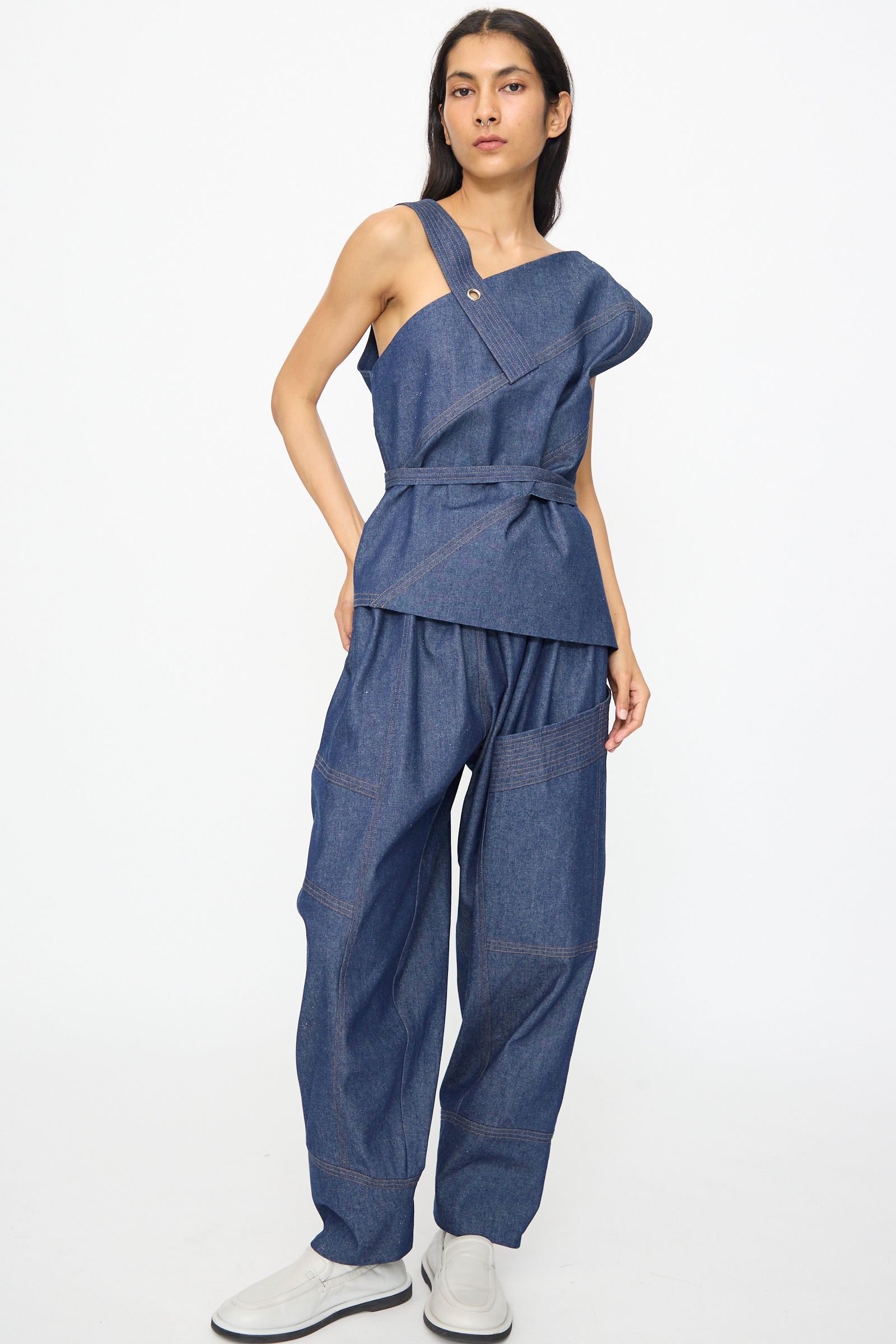 A person wears the SC103 Denim Sail Top in Soft Indigo, paired with loose-fitting denim pants and white shoes, standing against a plain white background.