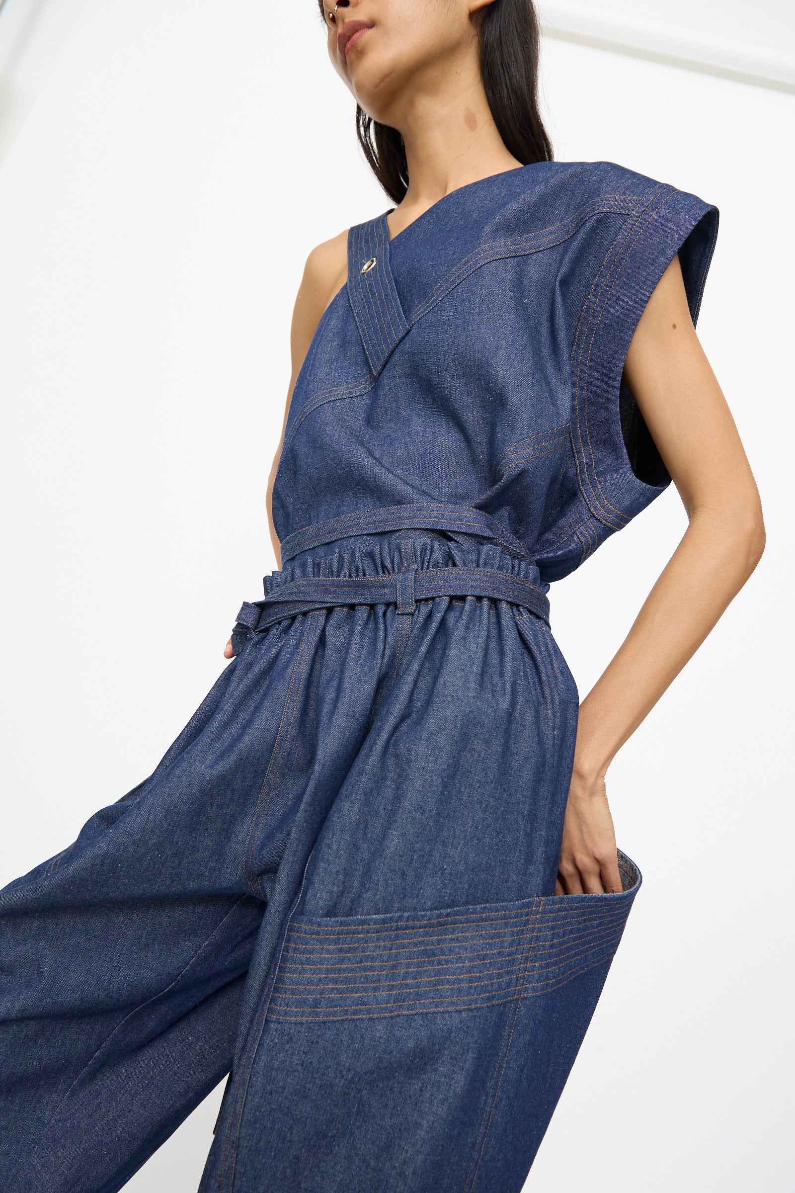 A woman stands against a plain background wearing the SC103 Denim Vault Pants in Soft Indigo, featuring a relaxed fit and wide legs.