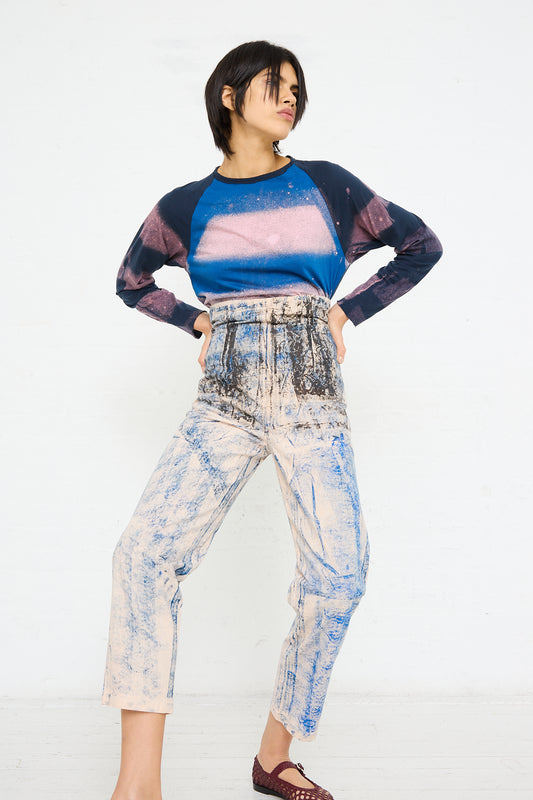 Woman posing in a colorful outfit with a SC103 Lace Print Cotton Legend Trouser in Ink against a white background.