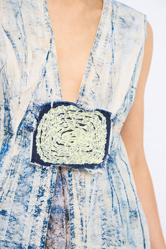 Close-up of a woman wearing a dress with an SC103 Abstract Blue Print Lace Print Cotton Pageant Vest in Ink and handmade details.