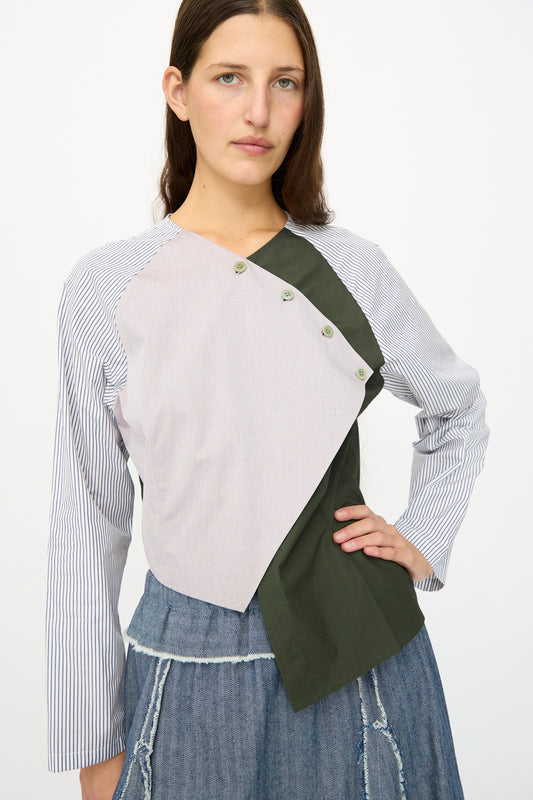 A woman poses with one hand on her hip, wearing the SC103 Poplin Mix Peak Blouse in Horizon with a denim skirt—thoughtfully made in NYC.