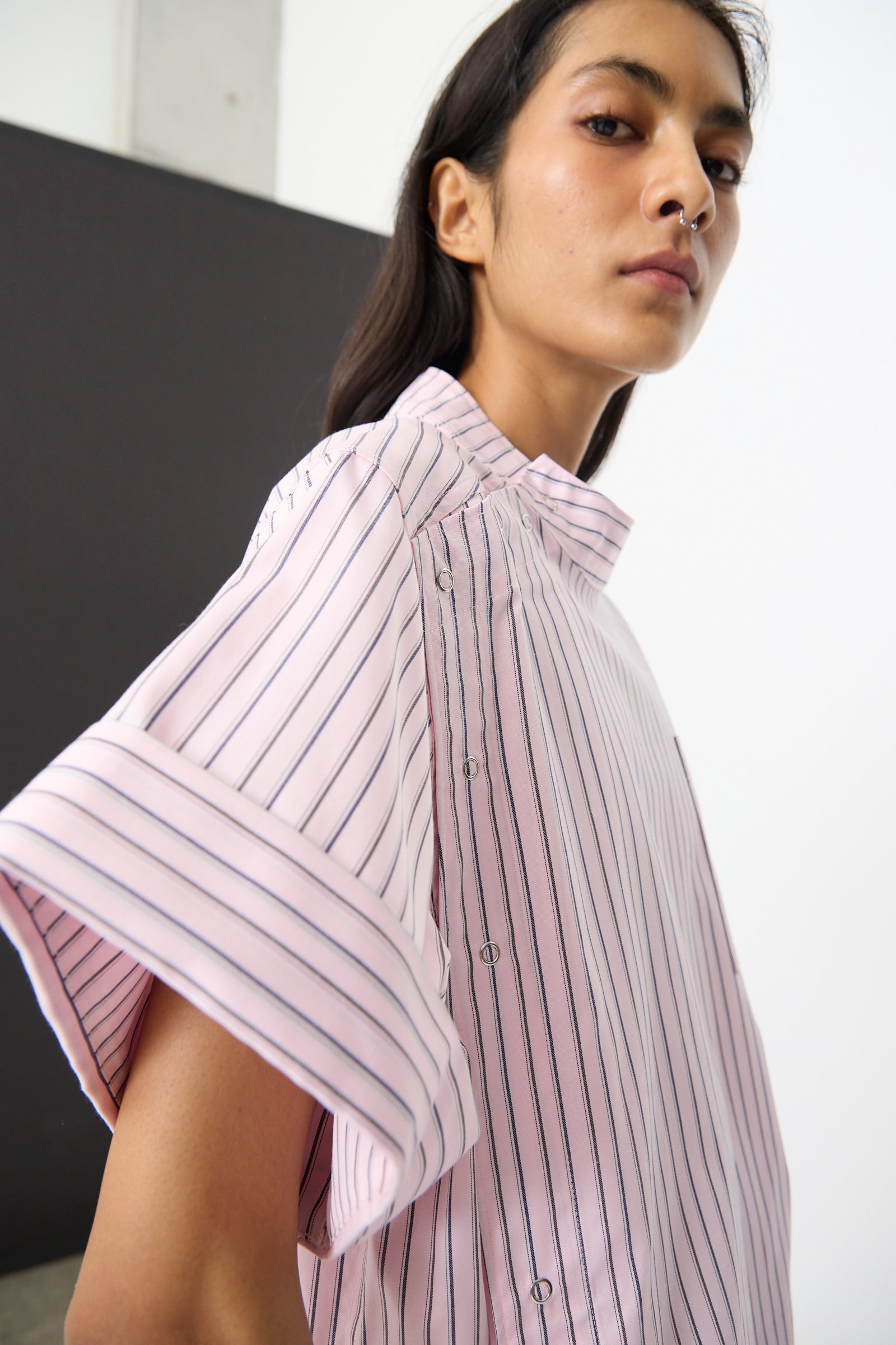 Person wears the SC103 Stripe Cotton Wish Top in Blushline, a pink cotton top with black vertical stripes and short sleeves, posing confidently against a minimal background.
