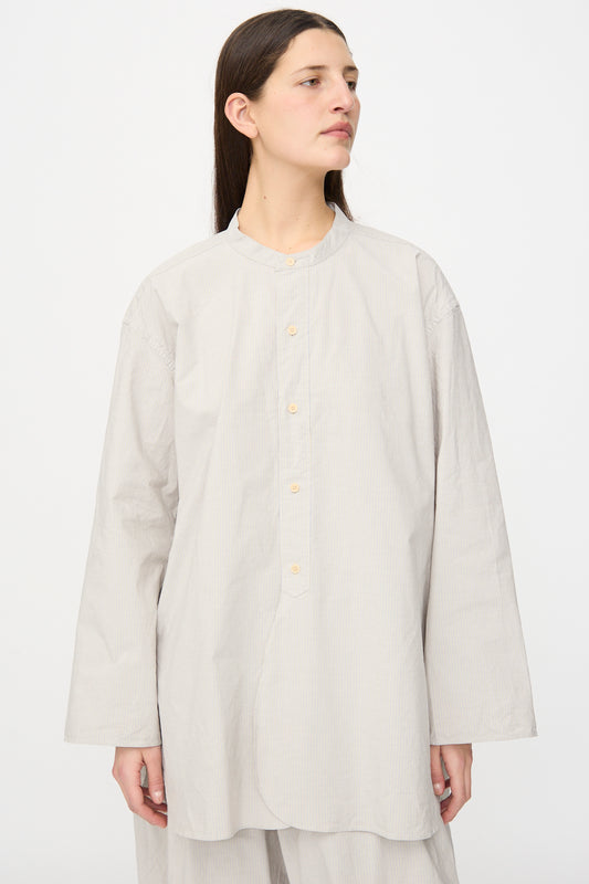 Model wearing the SONO Shaman Shirt in Dusty Fine Stripe, an oversized long sleeve shirt with a stand collar, posed against a plain white background.