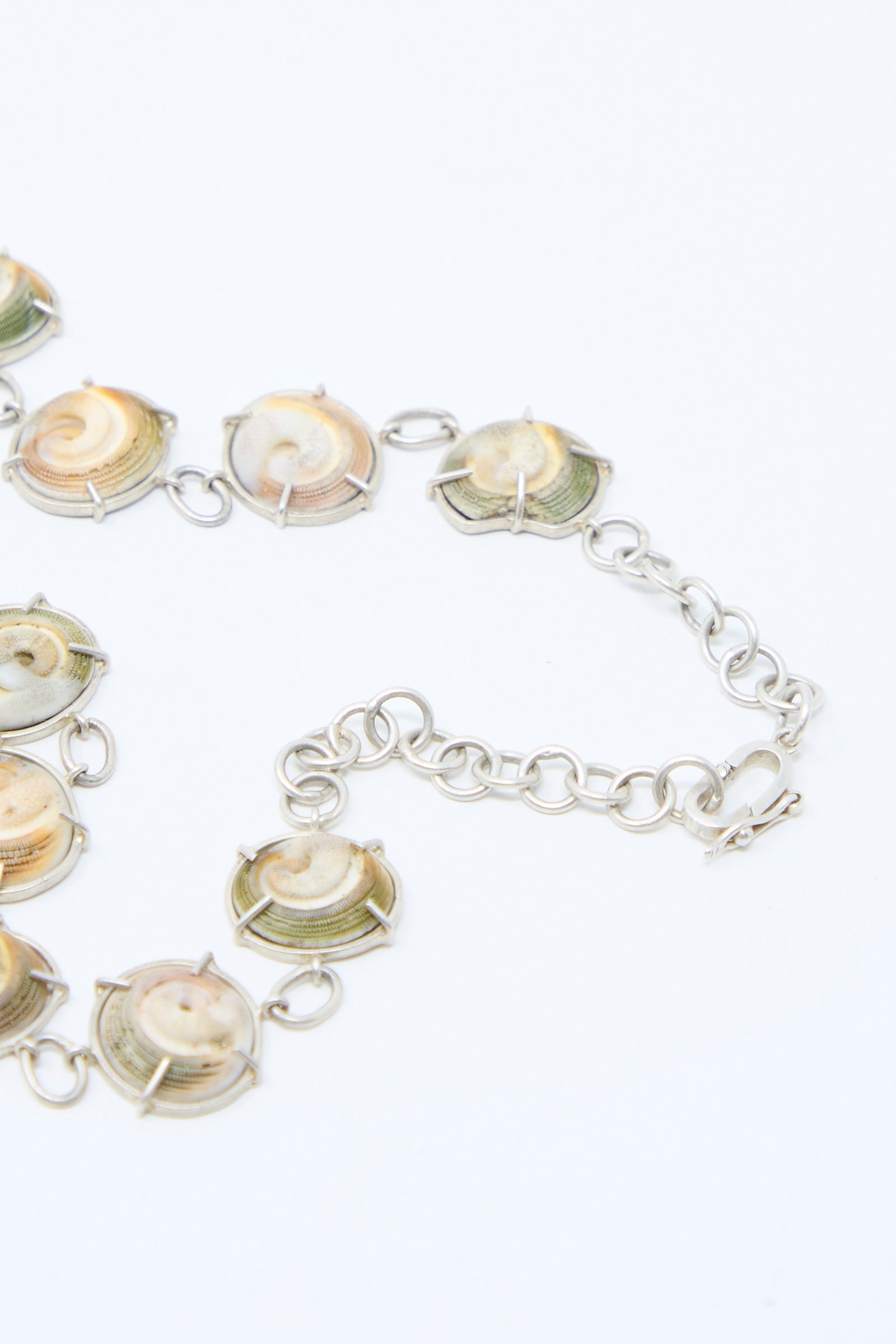 Close-up of La Ma r's Sterling Silver Necklace in Shell, featuring round, multicolored shell pendants on a light background.