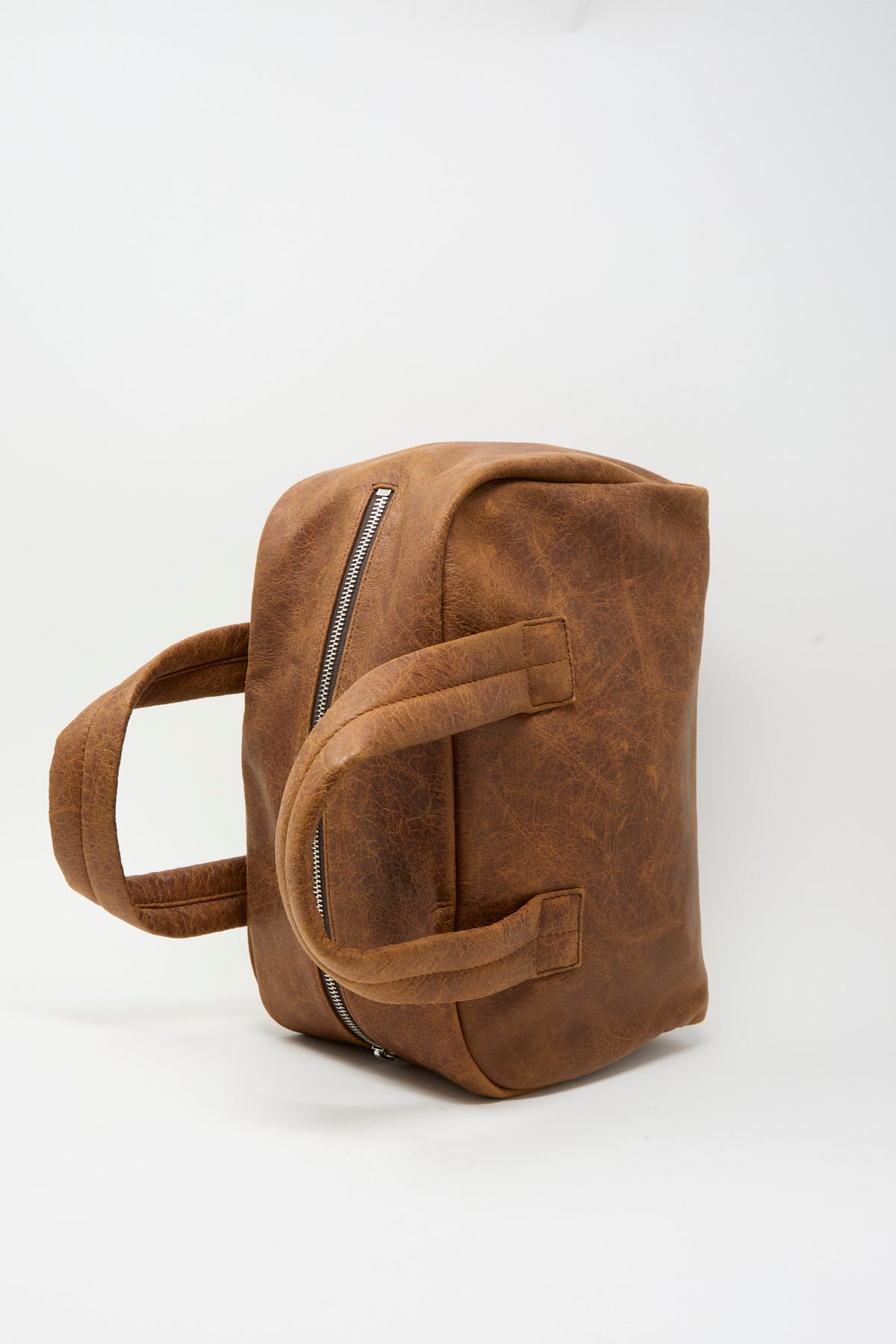 Sabina Leather The Bowling Bag in brown with two handles and a top zipper.