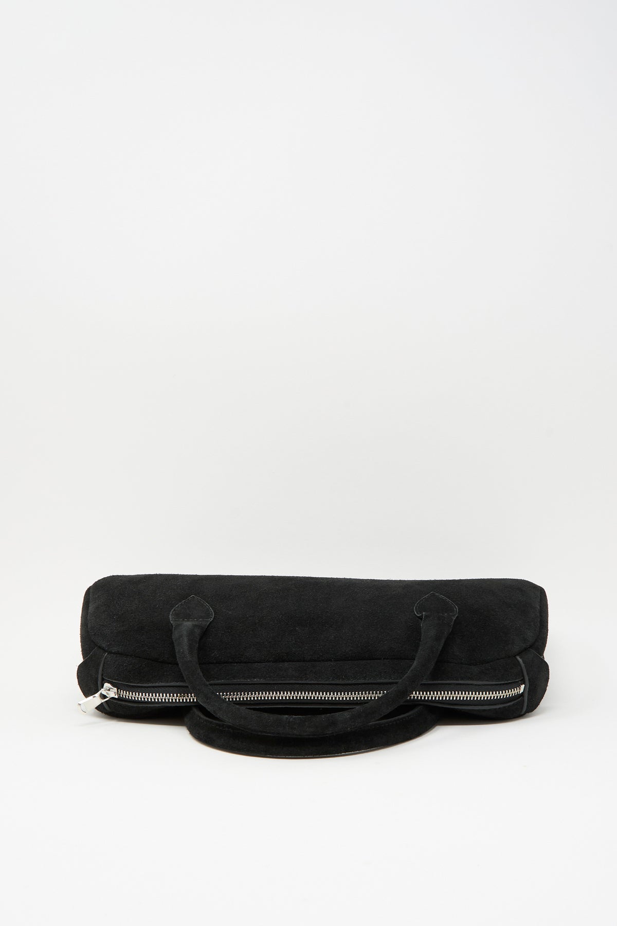 Sabina Suede The Bottle Bag in black, a small cylindrical bag with a top zipper closure and two short handles.