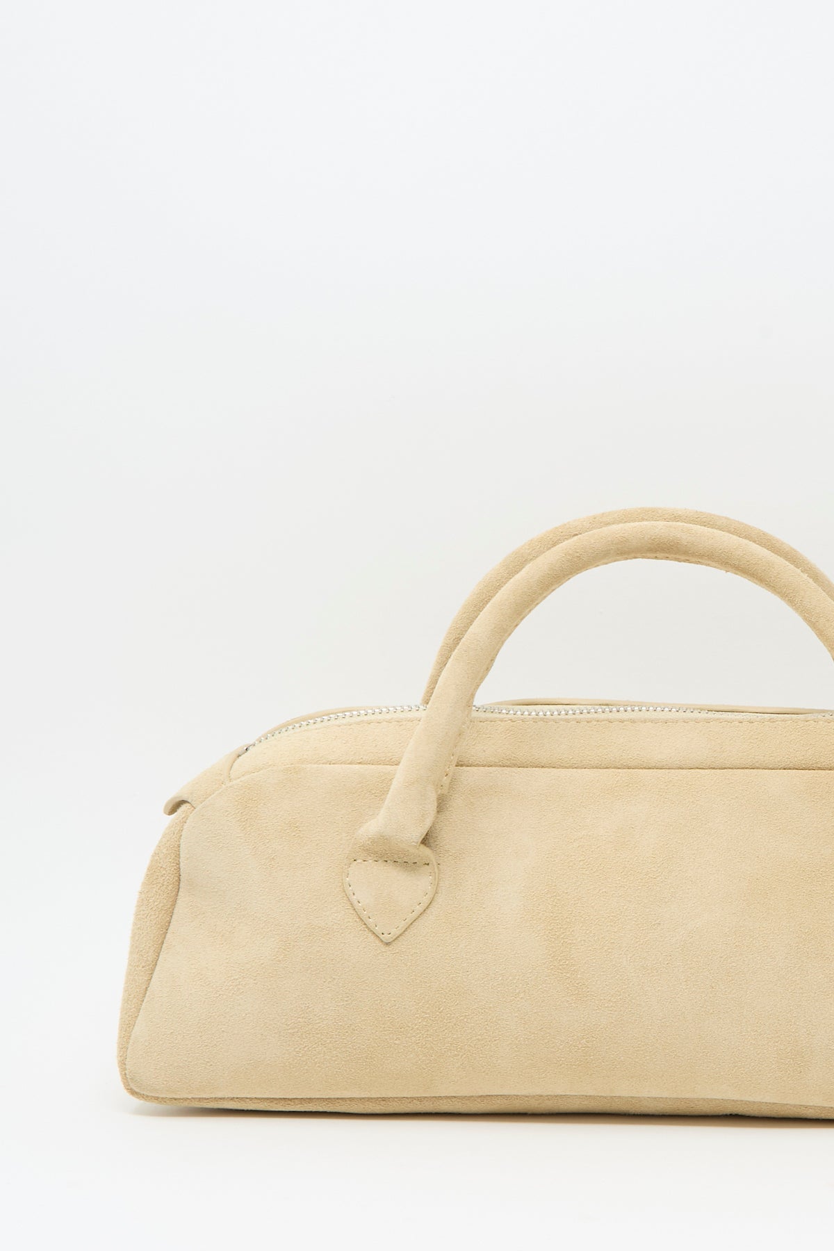 Sabina Suede The Bottle Bag in cream, a small handbag featuring a top handle and zippered closure.