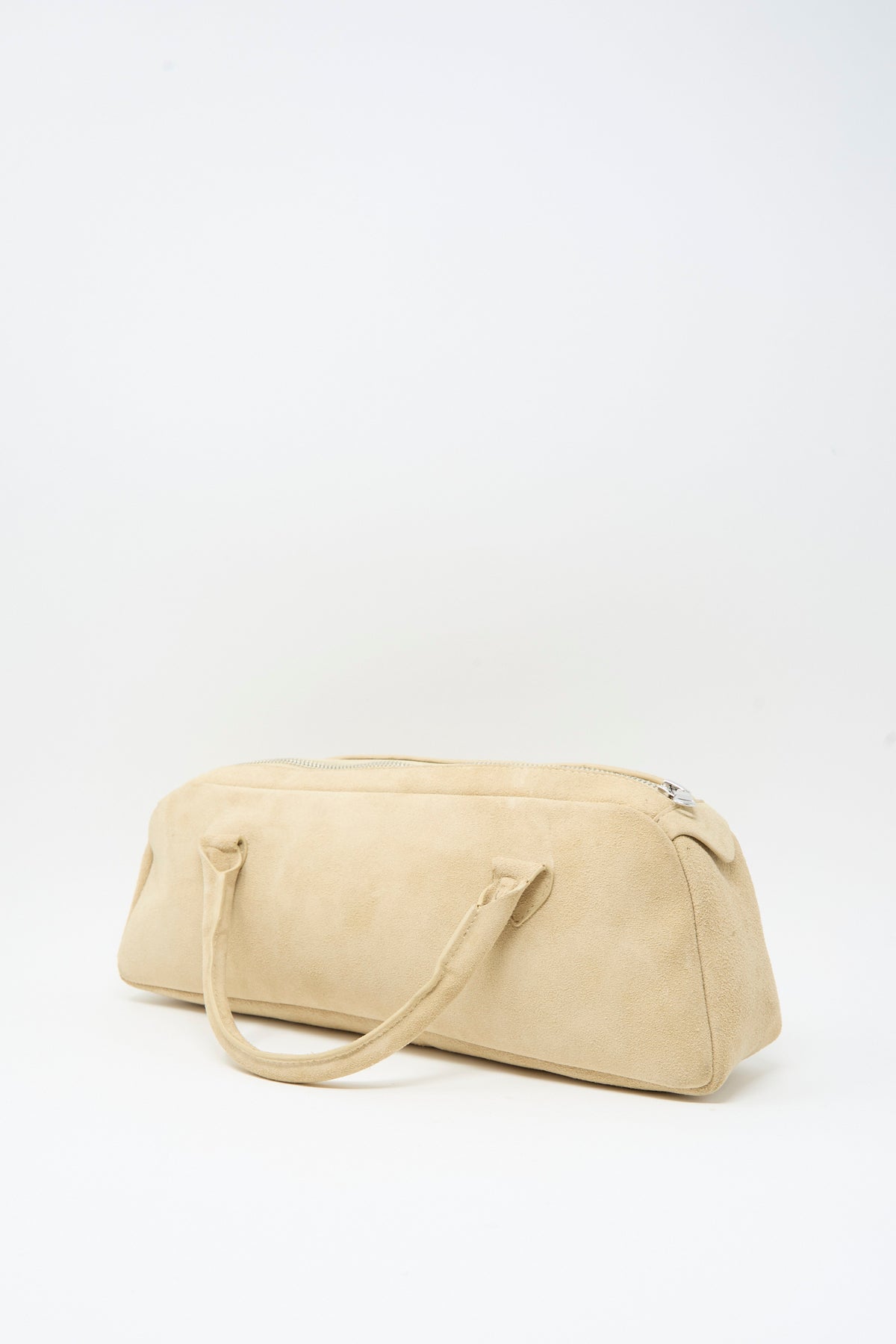 Cream-colored suede Suede The Bottle Bag with a cylindrical shape, two handles, and a top zipper.