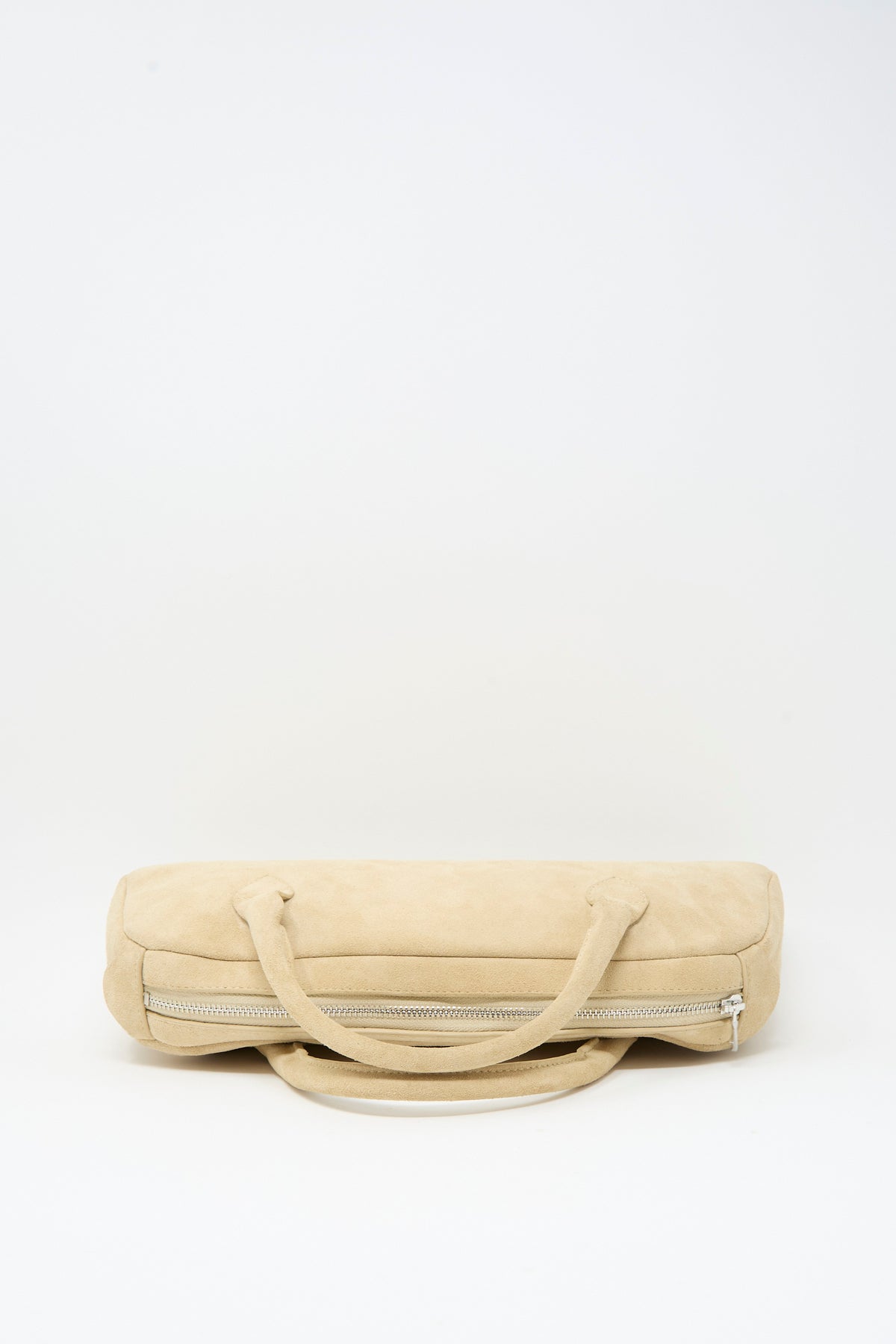 Sabina Suede The Bottle Bag in cream, a cylindrical suede bag featuring two handles and a side zipper.